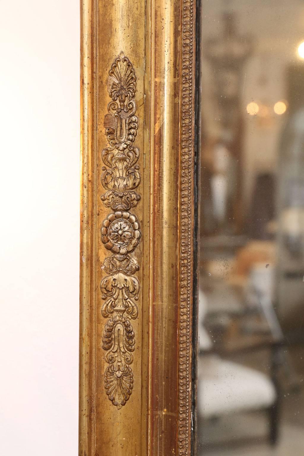 Large giltwood Empire mirror, (circa 1820-1840), with palmettes en doré motif along frame and its original silvered mercury plate mirror (two pieces), that features a gorgeous 'diamond dust' effect across its surface.