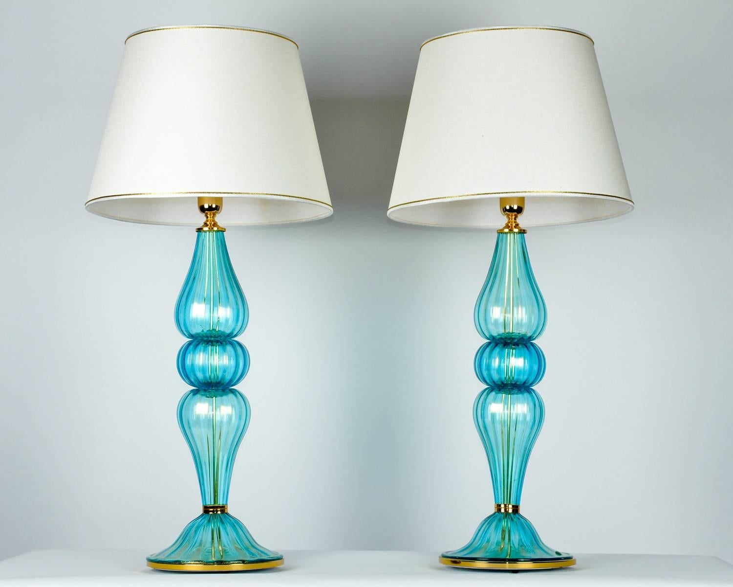 Gold flecks design details with brass base Murano glass pair table lamps. Each lamp is in excellent working condition and has been recently rewired for US use. Each one measure 34 inches high x 5 inches body diameter x 9 inches base diameter. These