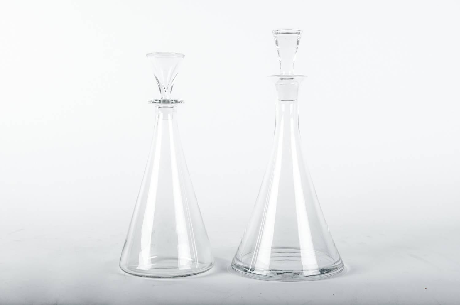 Mid-20th century pair of Baccarat crystal Art Deco style drinks decanter set. . Each decanter is in excellent vintage condition. Taller decanter measure 13.5 inches high x 6 inches base diameter. The shorter one measure 12 inches high x 5 inches