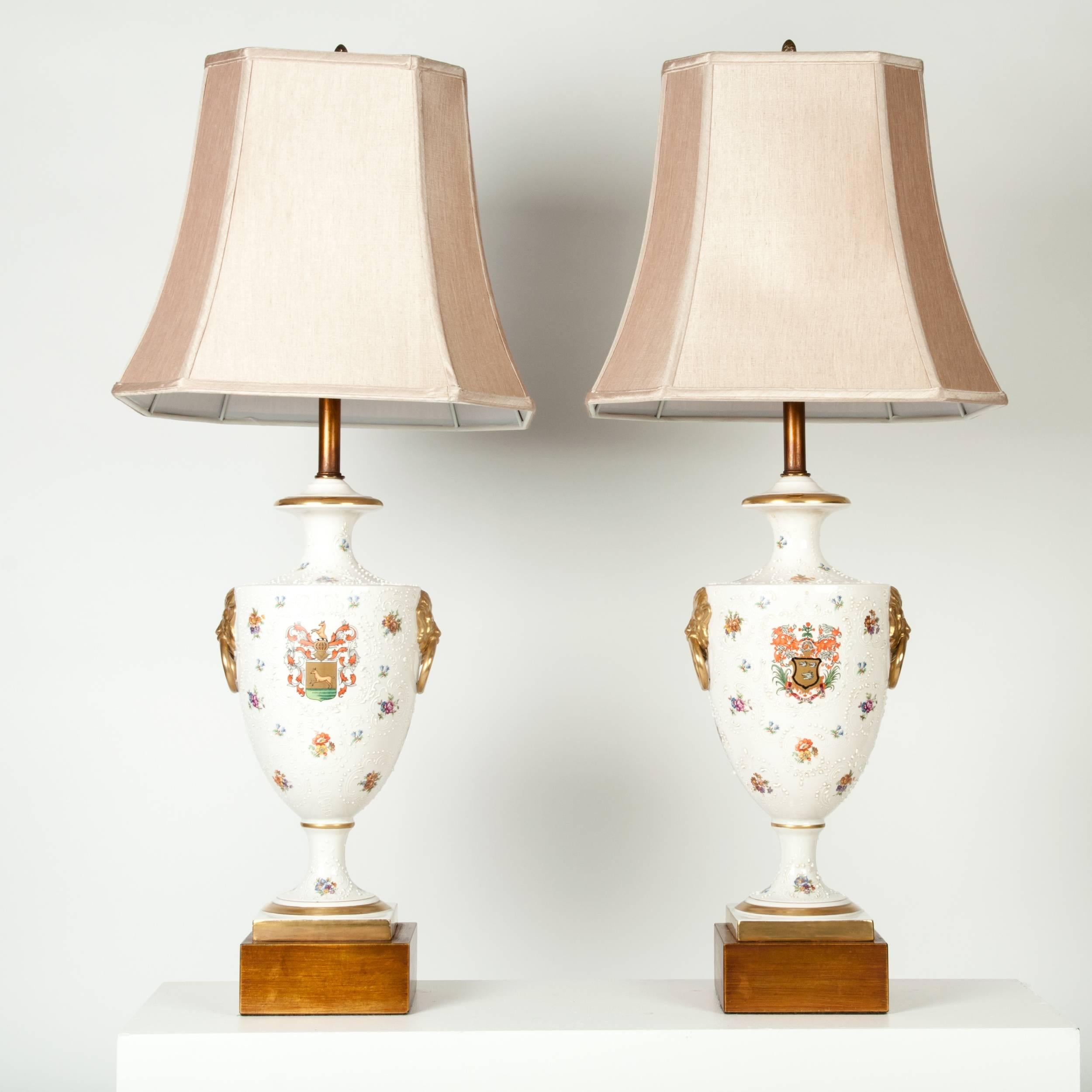 Antique pair of porcelain European table / task lamps with gilded wooden base with beige drum shade. Each lamp measure 38 inches high x 7 inches width base. Each shade measure 10 inches top x 16 inches bottom x 14 inches long.