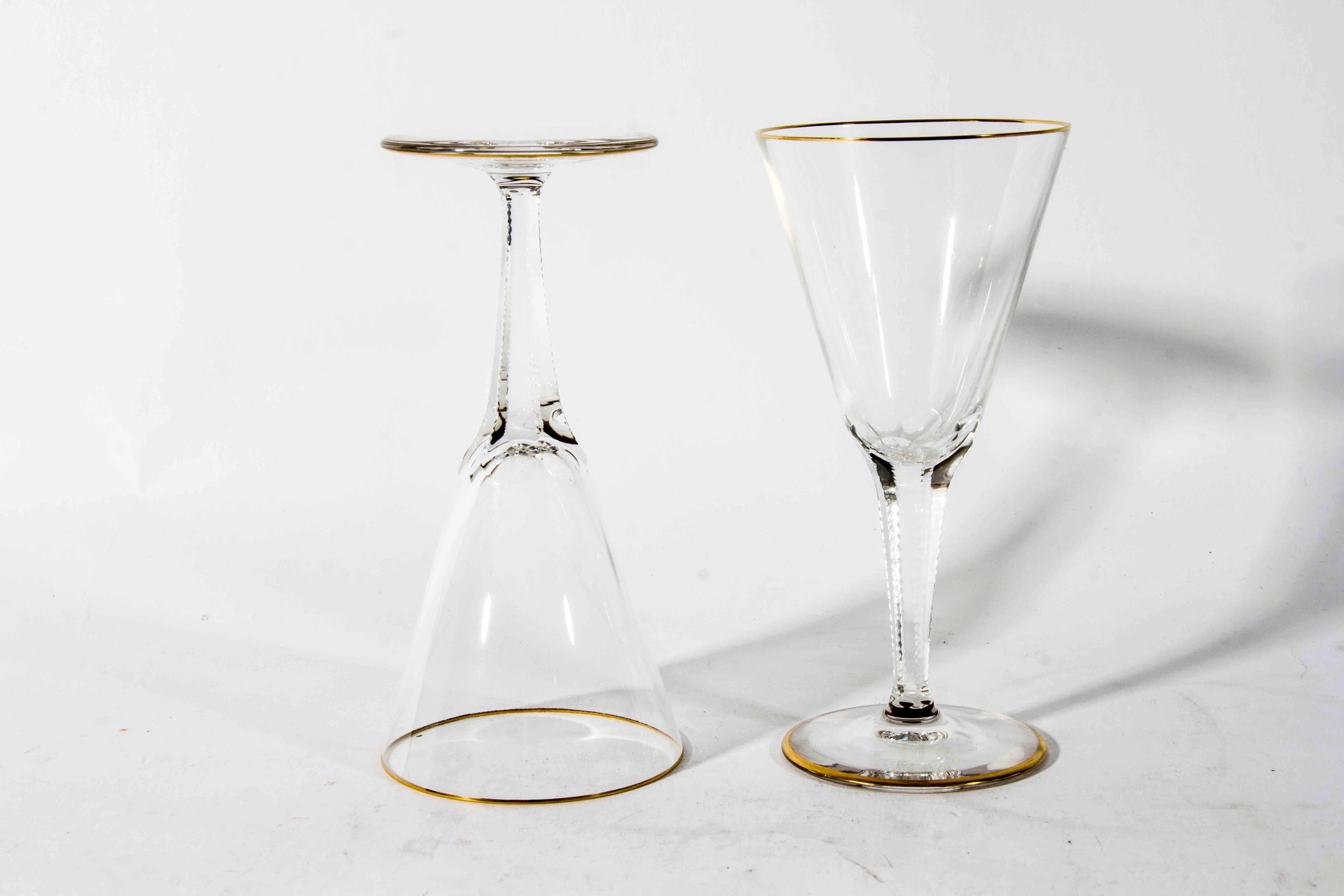Antique set of crystal wine stamped glasses with gold trimmed top and base. The glasses are in excellent condition. The glasses measure 6.5 inches high X 3 inches diameter.