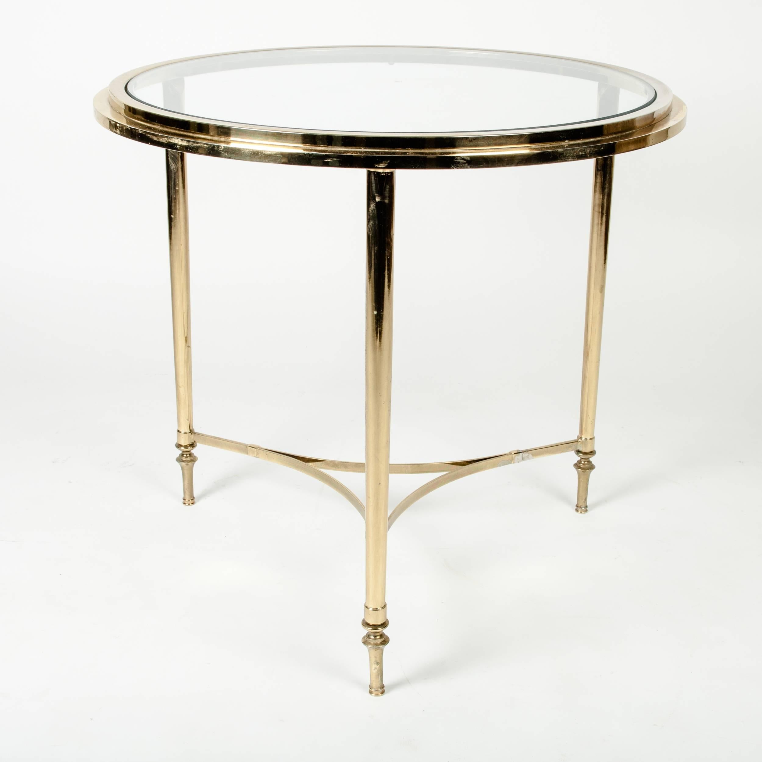 Vintage round solid brass side / end table with glass top. The table measure 22 inches high x 23 inches diameter.