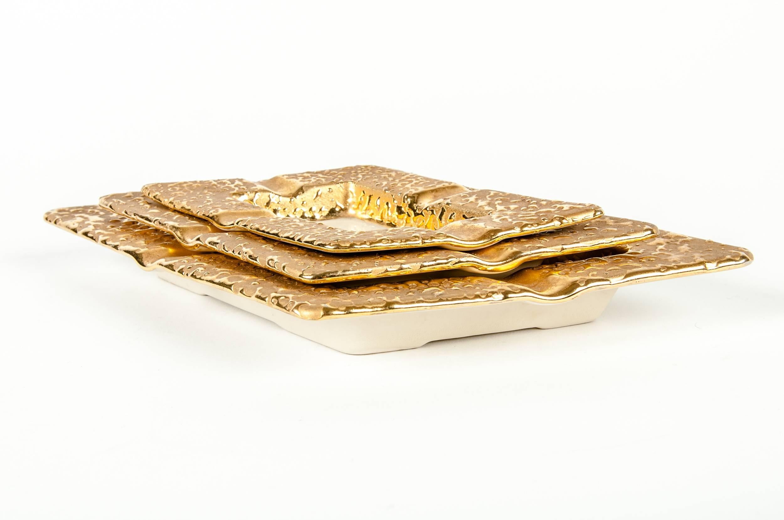 Vintage set of porcelain hand decorated 22-karat gold ash tray set. Large ash tray measure 9 inches x 7 inches. Medium ash tray measure 7 inches x 5 inches. Small ash tray 6 inches x 4 inches.
