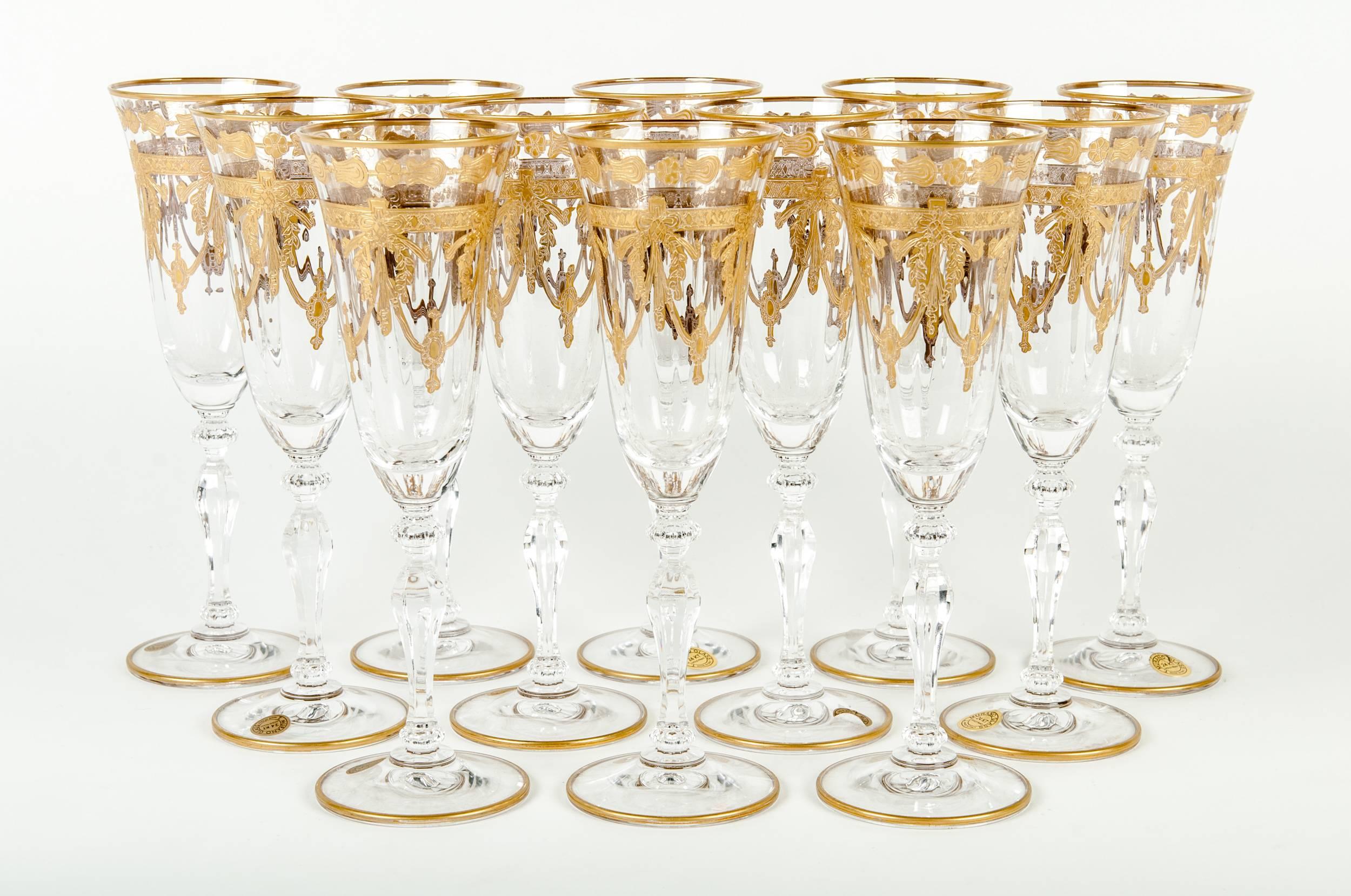 Set of twelve Murano champagne flute with 24-karat gold design. Each champagne flute measure 8.5 inches high x 2.5 inches diameter.