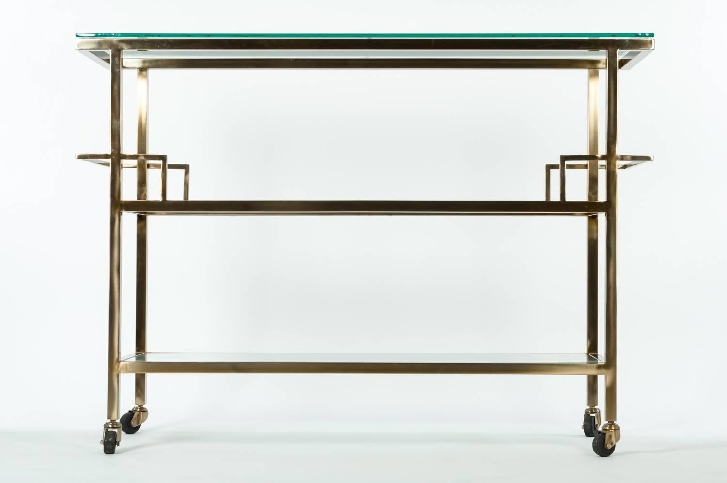 Mid-Century solid brass wheeled bar cart with glass top and two shelves. The brass bar cart measure 50 inches long X 36.5 inches high X 15.5 inches width.
