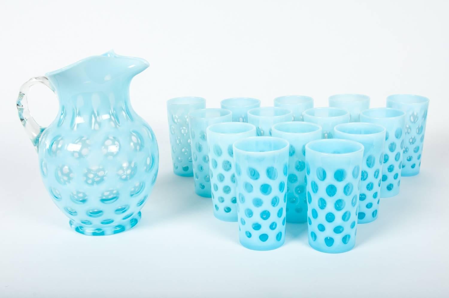 Vintage blue opalescent coin dot fenton 15-piece set. The set Include one large pitcher 10 inches tall x 7 Inches wide and 14 drinks glasses each one measure 5.2 inches tall x 3 inches wide. Excellent condition.