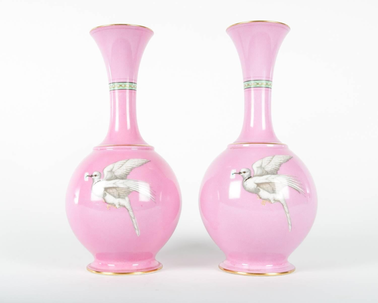 Pair of vintage English pink decorative vases with hand-painted swallows and doves. Gilt lip and base. Measures: 12 inches tall and 6 inches wide each.