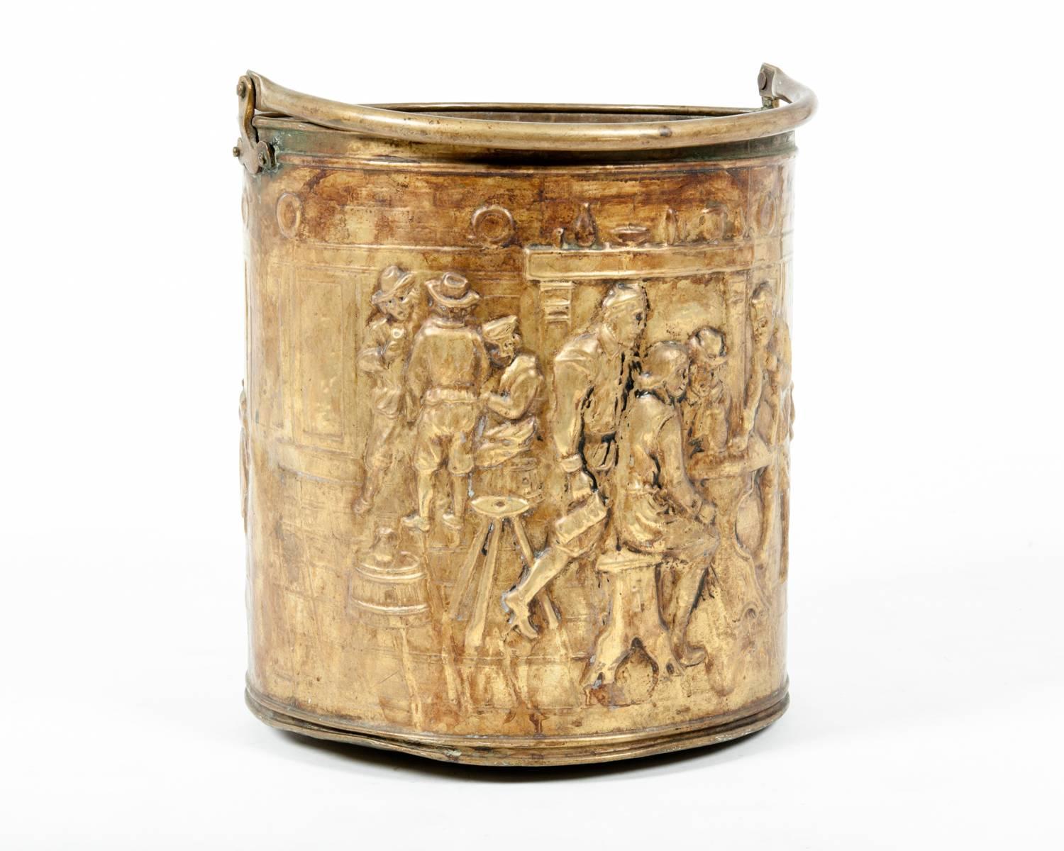 Antique English brass fire log or ash bucket, with heavily embossed scene. Brass handle.