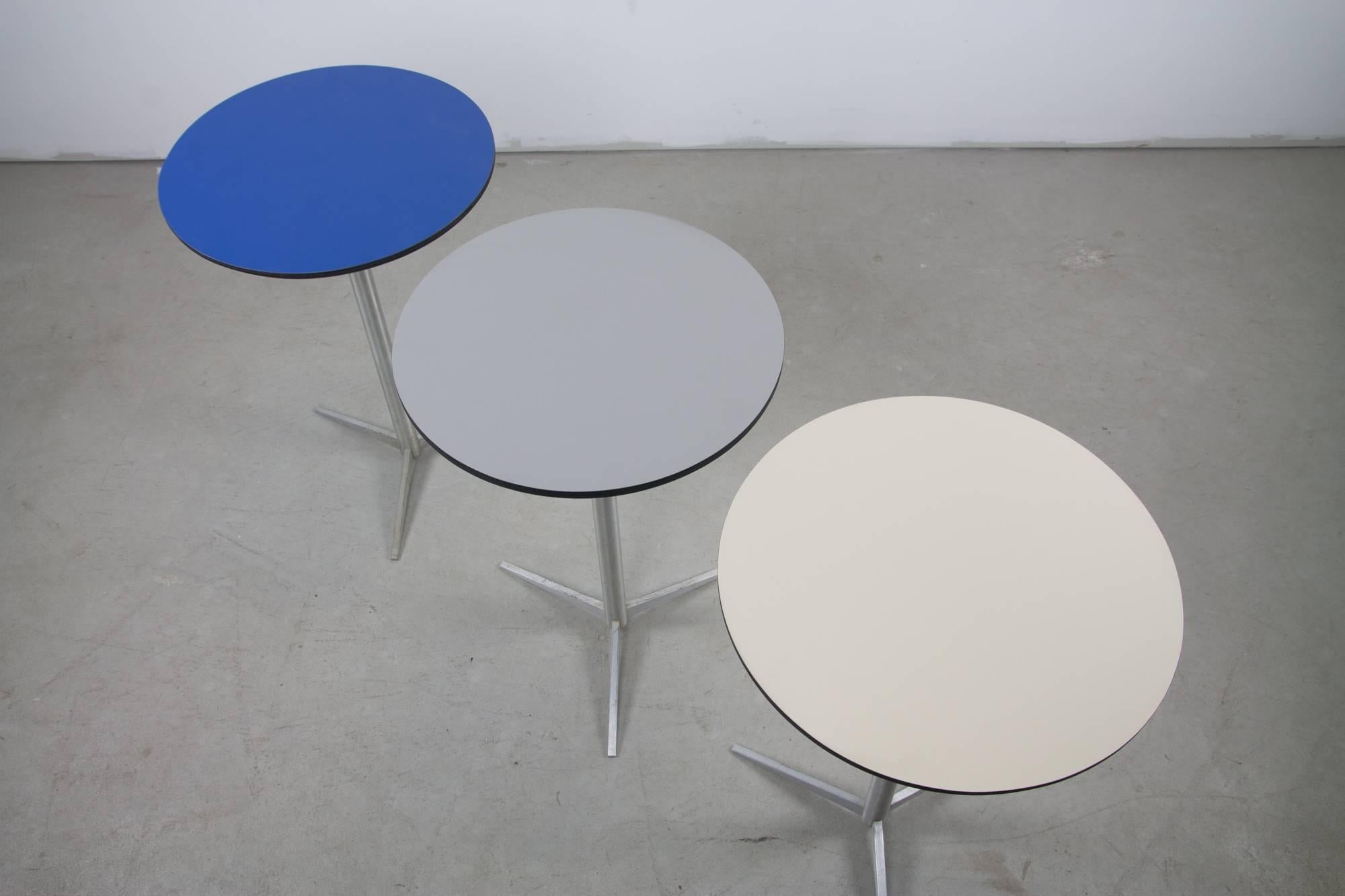 A scarcely seen set of three drink tables by Paul McCobb for Thonet with stunning, lightweight aluminum bases and custom laminate tops in blue, grey and white.