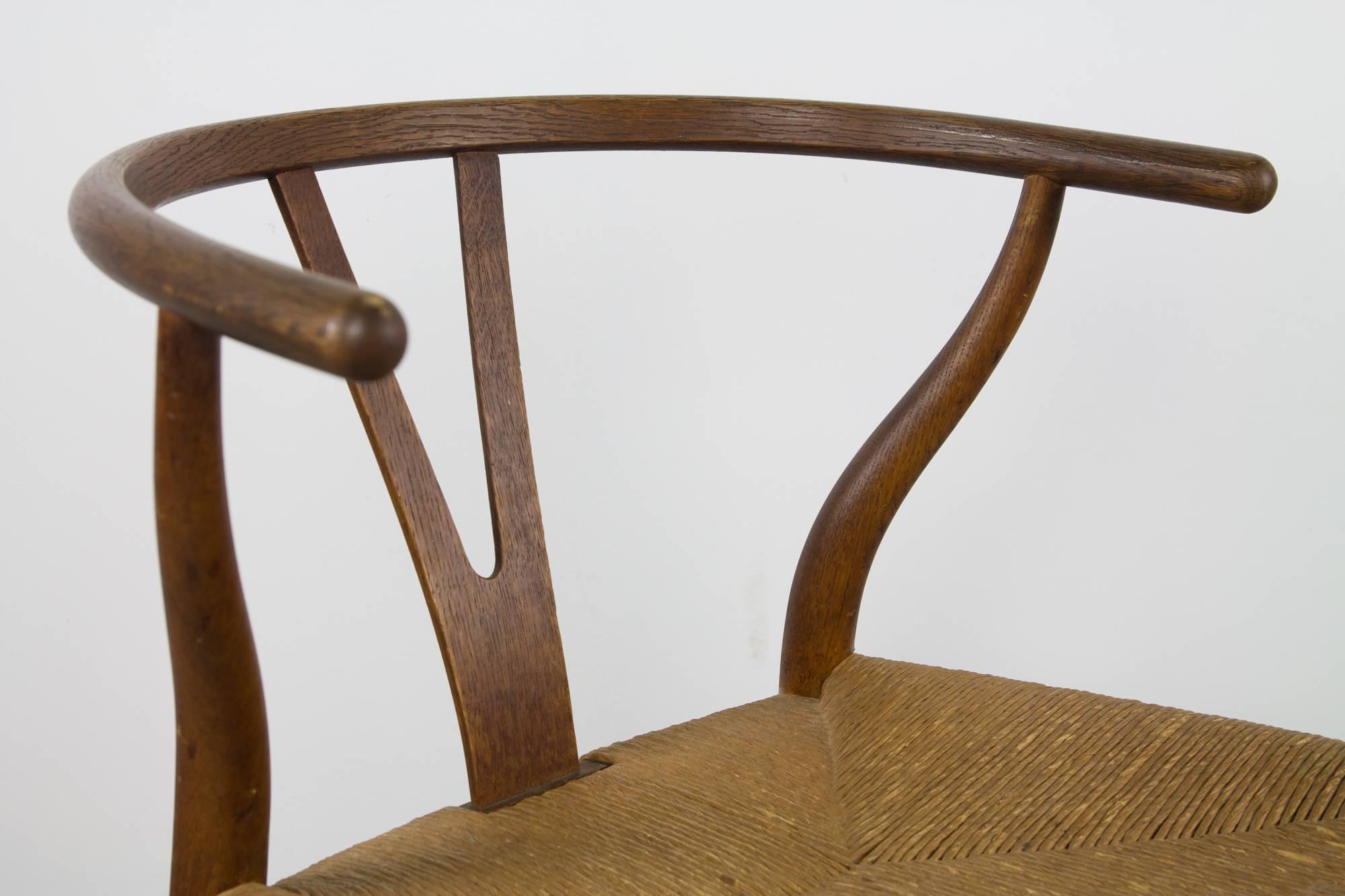A gorgeous and early example of the CH24 'Wishbone', or 'Y' chair in walnut by Hans Wegner. Aside from its comfortability and stunning design, this chair most impressively merges traditional forms of The Shakers (seat and base) and Ming dynasty