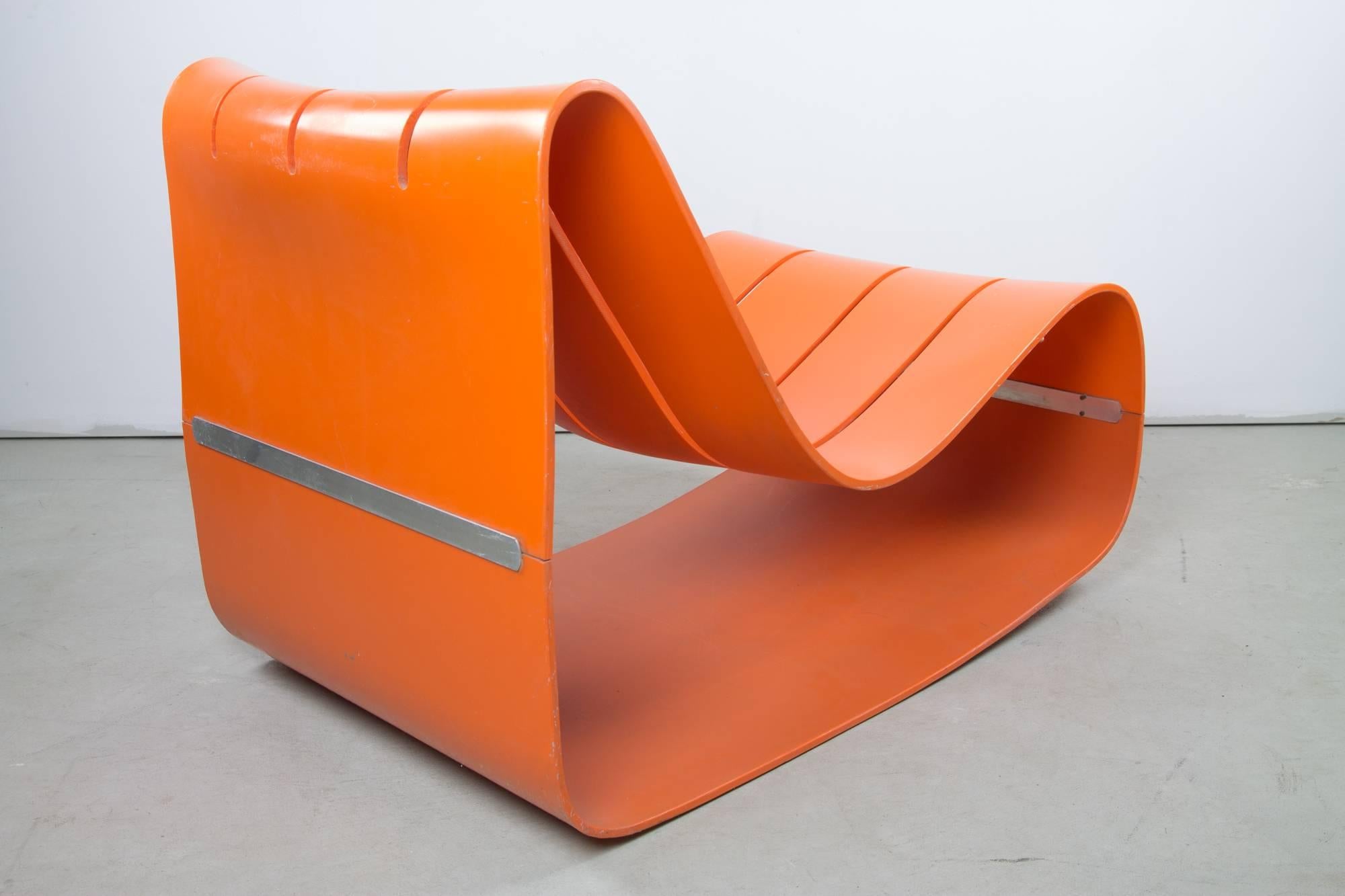 This very scarce chair by Motomi Kawakami for Alberto Bazzani is formed of two shells of orange ABS plastic, joined across their width at the lower back and front by a double metal bar screwed through from the inside of the shell. This forms a