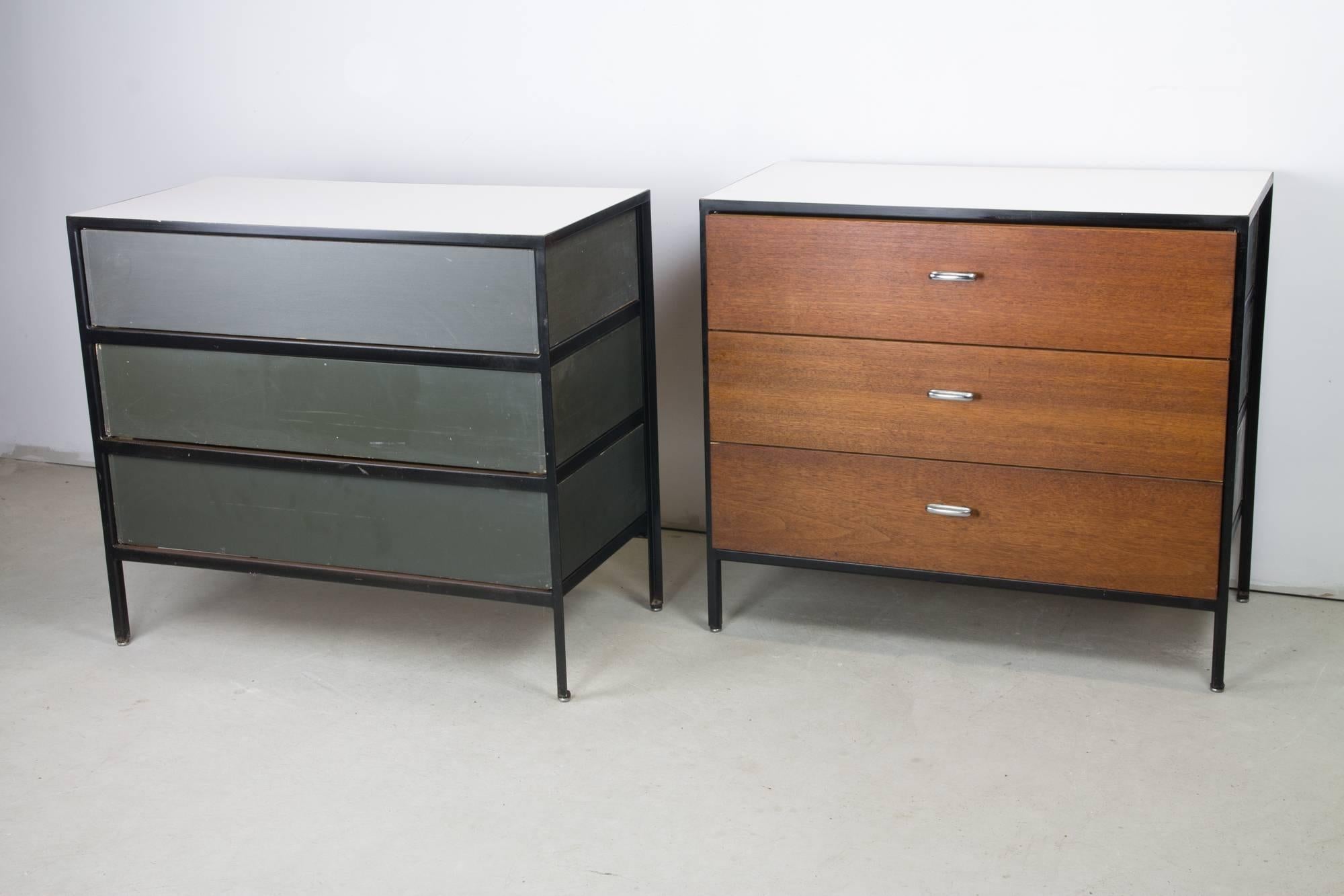 Pair of dressers by George Nelson as part of the Steel Frame line for Herman Miller. They feature external frames of blackened steel, three walnut front drawers, chromed pulls and white laminate tops.