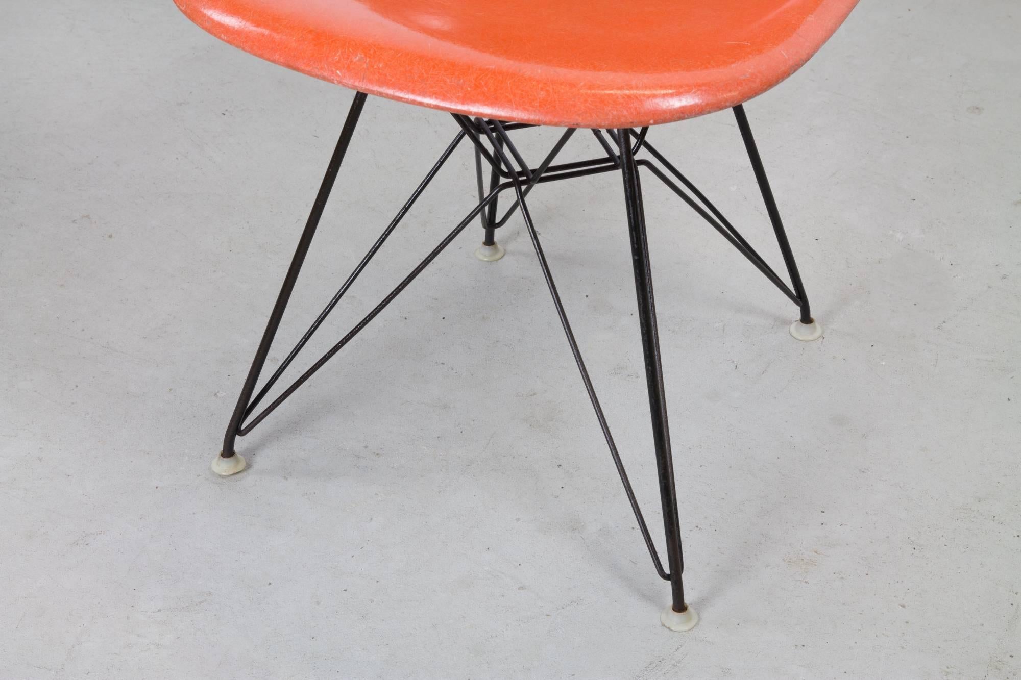 Herman Miller Eames DSR fiberglass chair on Eiffel base in rich orange. Base has excellent patina and original glides and shock mounts.