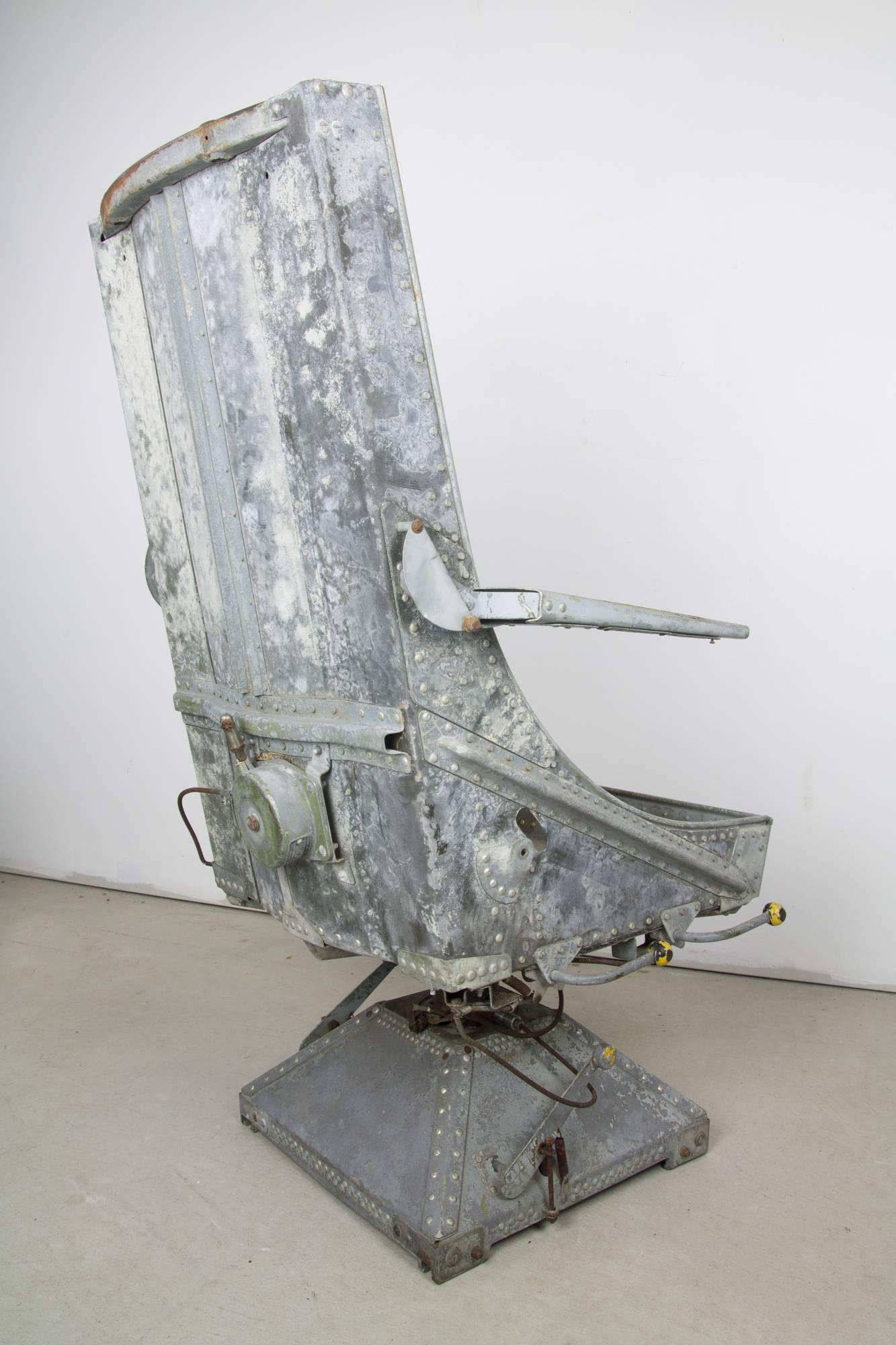 Rare aircrew seat by Aircraft Mechanics Inc. with swivel base. The body is riveted, galvanized, and well patinated. Adjustment levers have faded bright yellow spherical knobs. Ready for decorative purposes, or for use with the addition of a simple