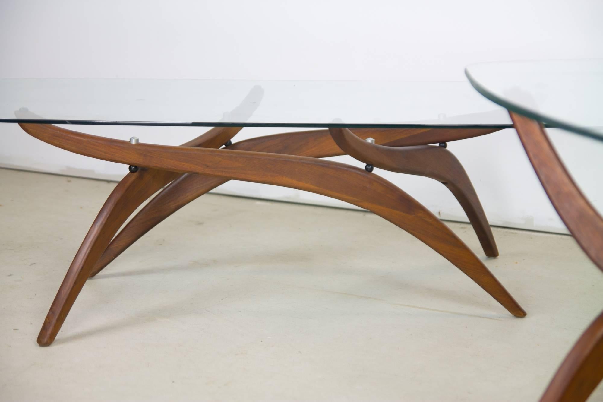 Elegant set of sculpted walnut tables by Forest Wilson with rounded rectangular 1/2 inch glass tops. One cocktail table and two side tables. Side table dimensions are H 21
