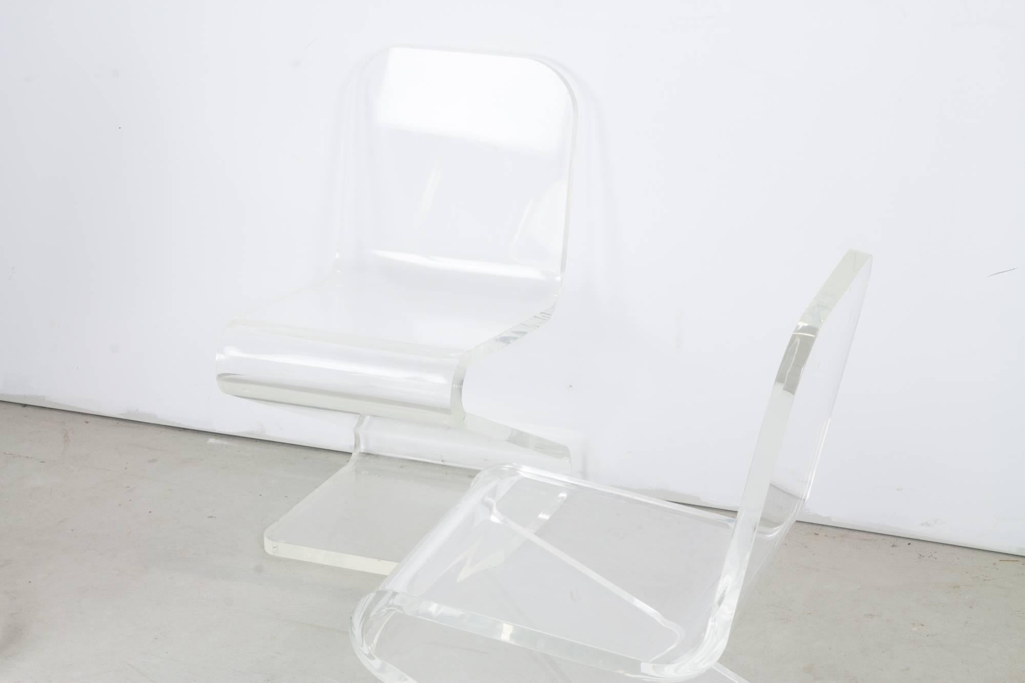 Here is a set of four beautiful acrylic chairs. They are physically very heavy while remaining visually very light. They are in very nice condition.