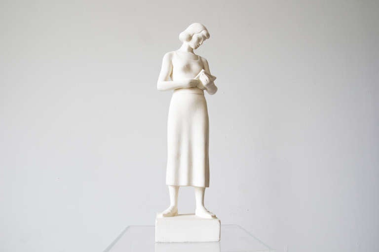A plaster sculpture signed by Maurice Glickman of a woman reading a book. Made under the Work Progress Administration, a program under the FDR New Deal to promote artistry throughout the United States.