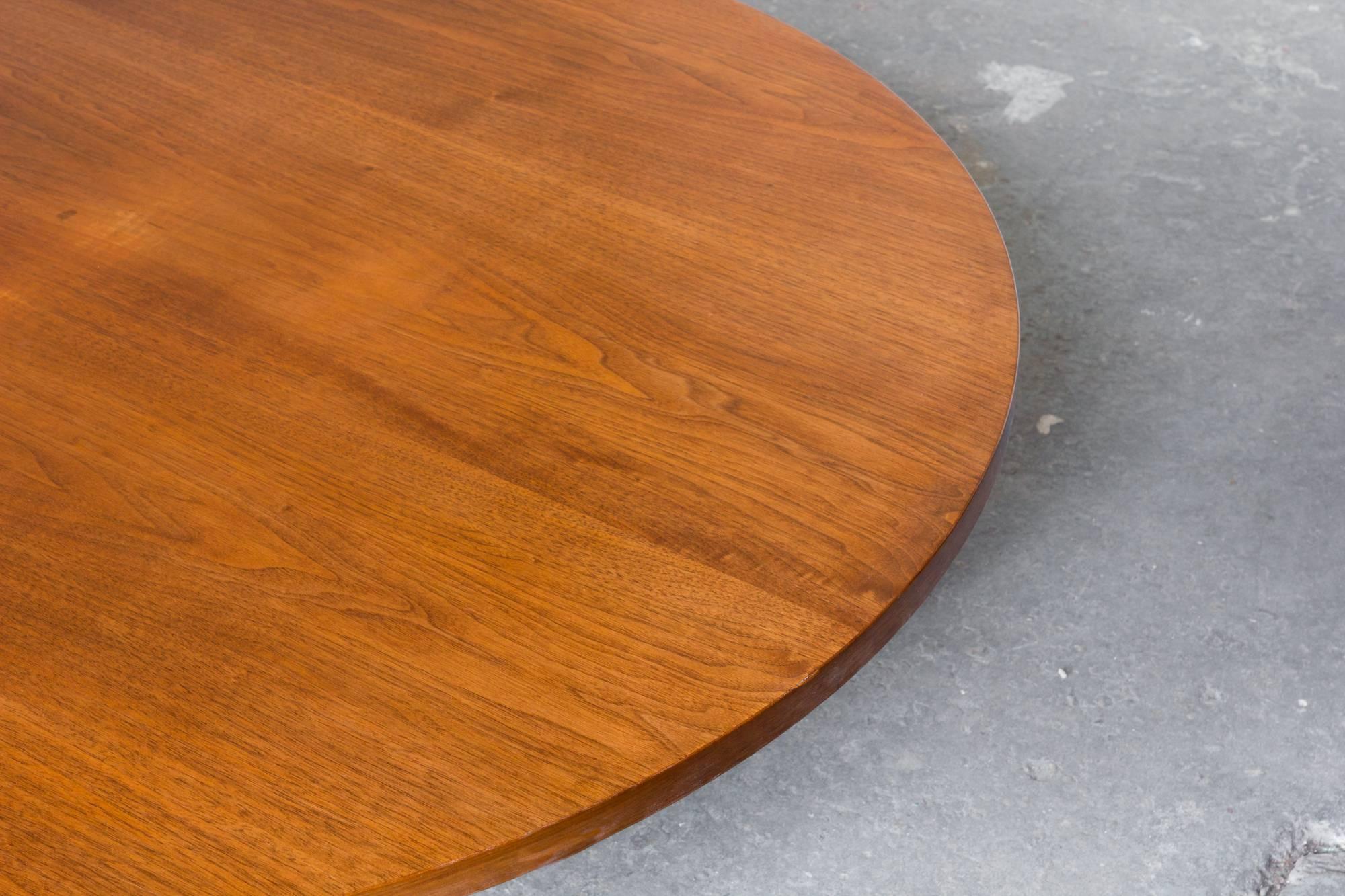 Low and well-proportioned circular coffee table in walnut and trimmed in aluminum by Paul McCobb for his 