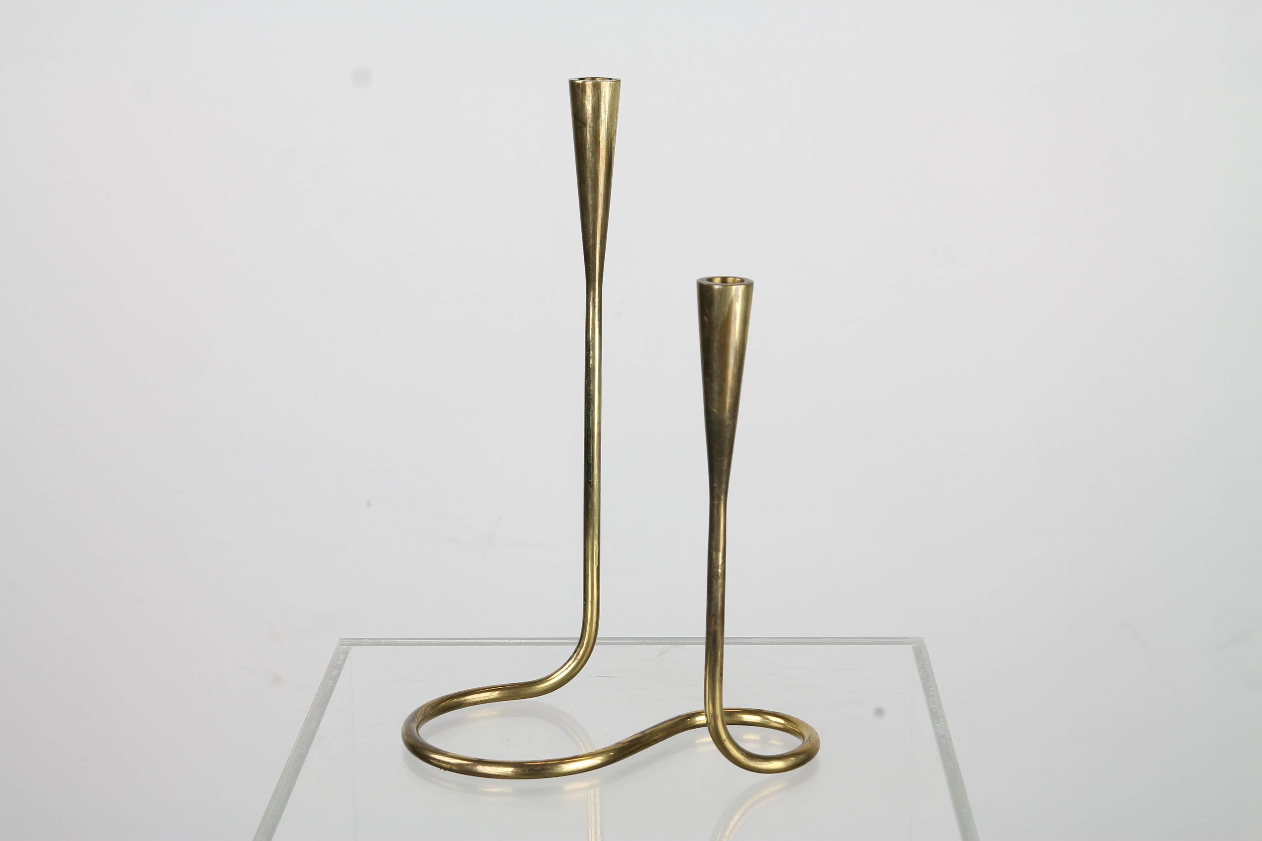 A pair of stunning serpentine-form candlesticks in solid brass by Illums Bolighus of Denmark, each having two holders for thin tapers at offset heights. Incised maker's mark on underside.