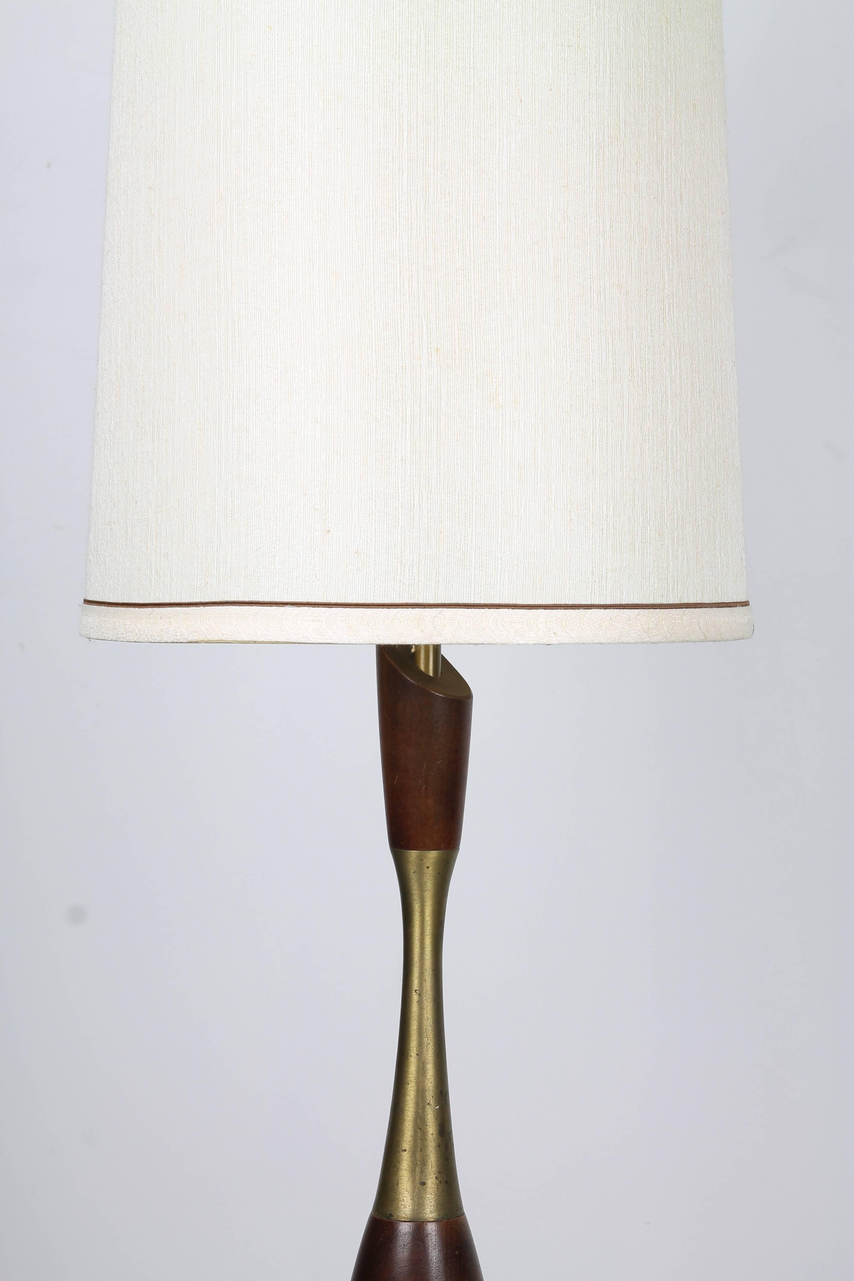 Lampe de table Tony Paul de forme organique en noyer tourné et éléments en laiton, avec un grand abat-jour cylindrique blanc cassé.