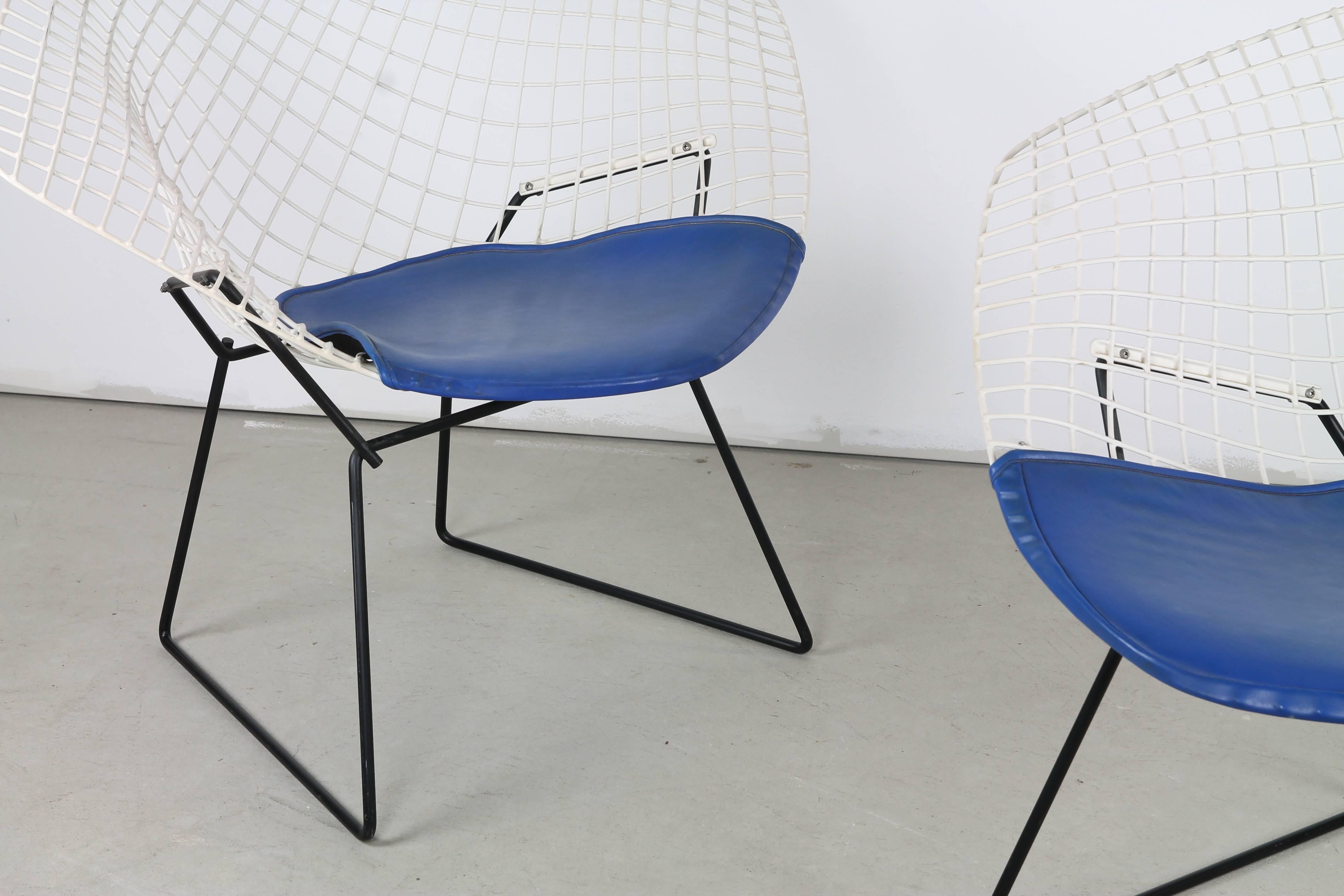 A pair of early 1950s #421 'Diamond Chairs' by Harry Bertoia for Knoll in black and white lacquer. They feature original blue seat cushions which retain their Knoll tags.