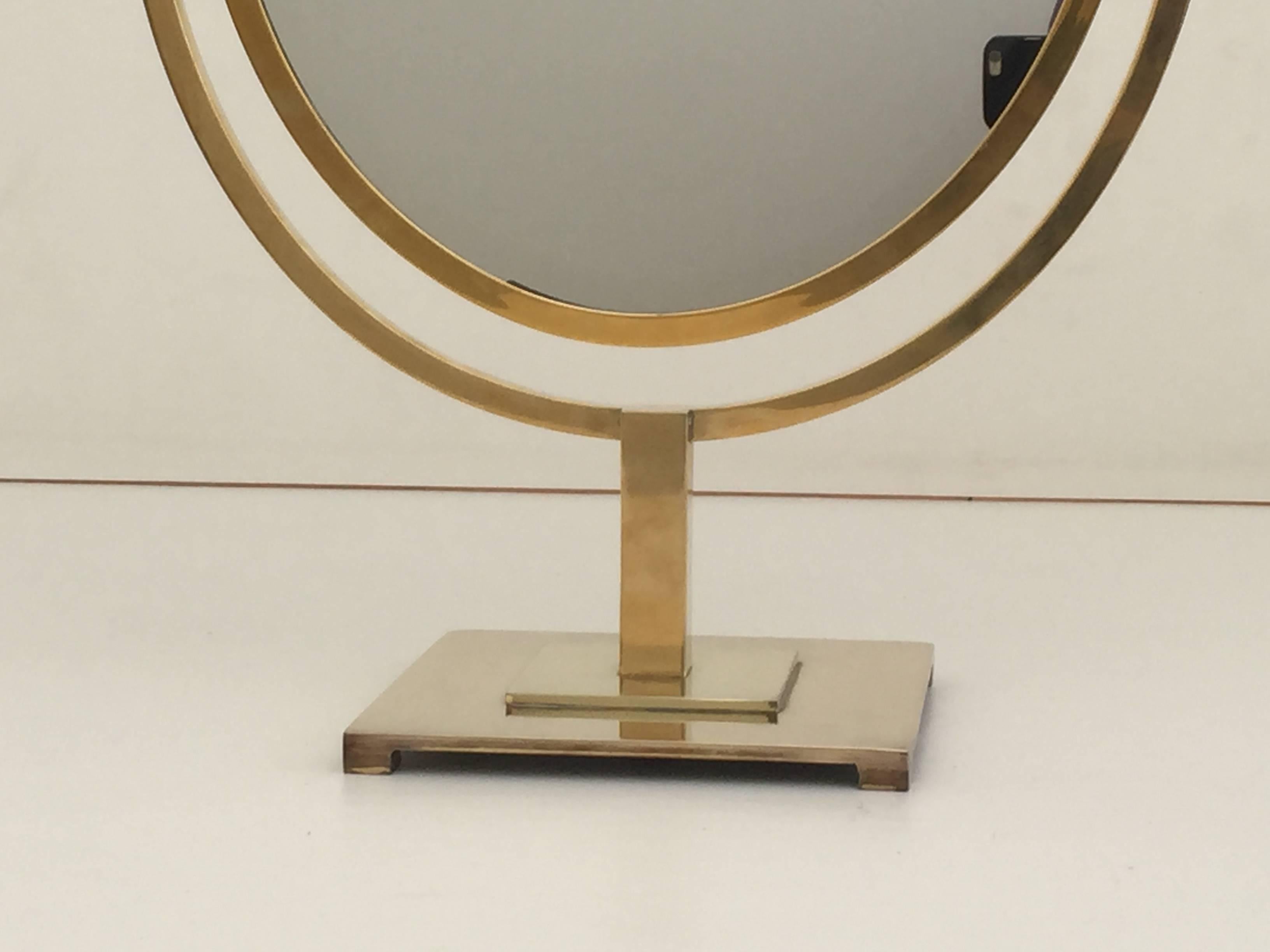 Double-sided oval brass vanity mirror.