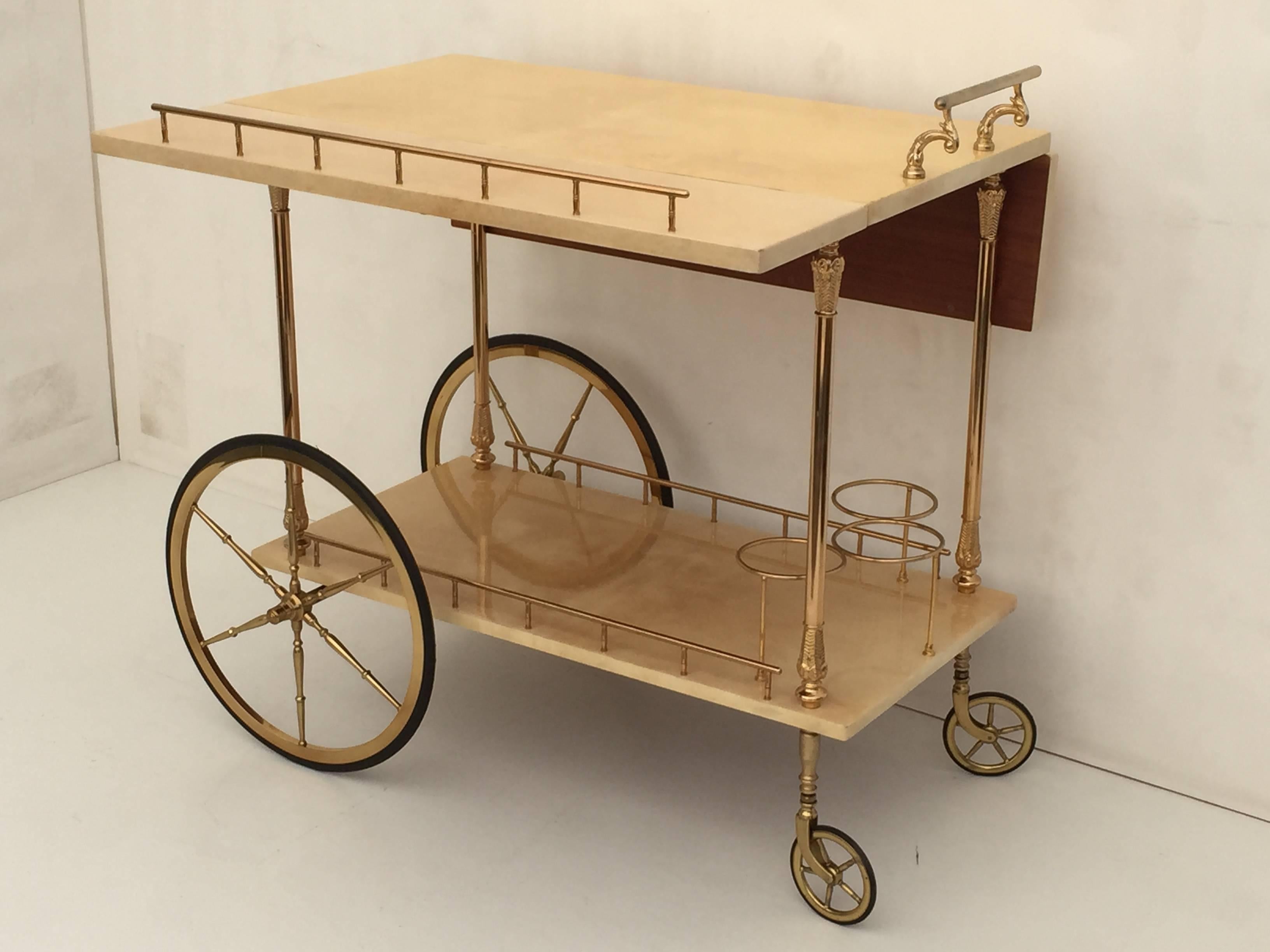 Aldo Tura parchment drop-leaf bar cart. Top in open position measures 29.25" by 29.5".
Drop leaves are faded from direct sunlight.