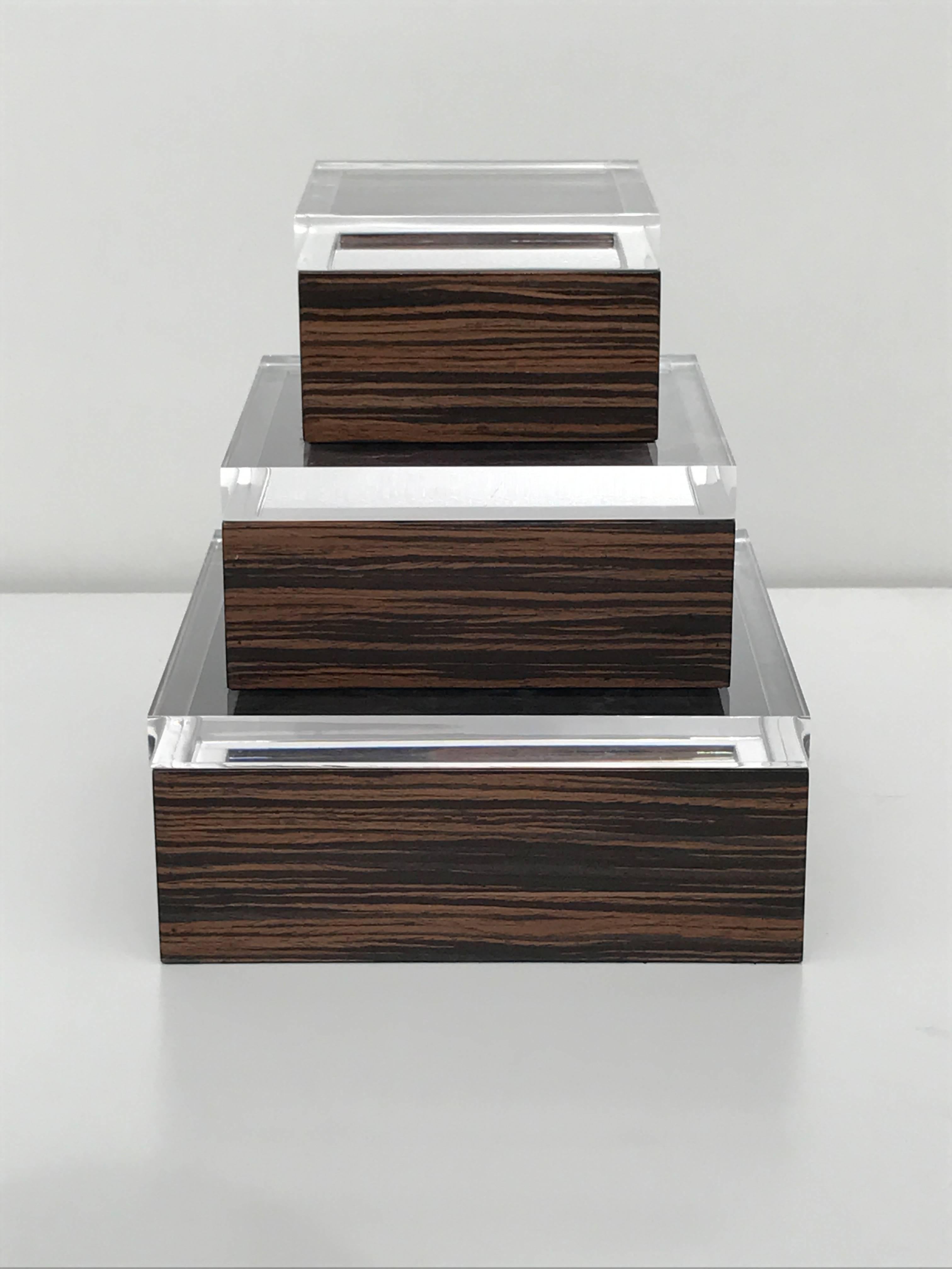 Set of three Macassar Ebony and Lucite jewelry boxes.
Measures: Large box 9