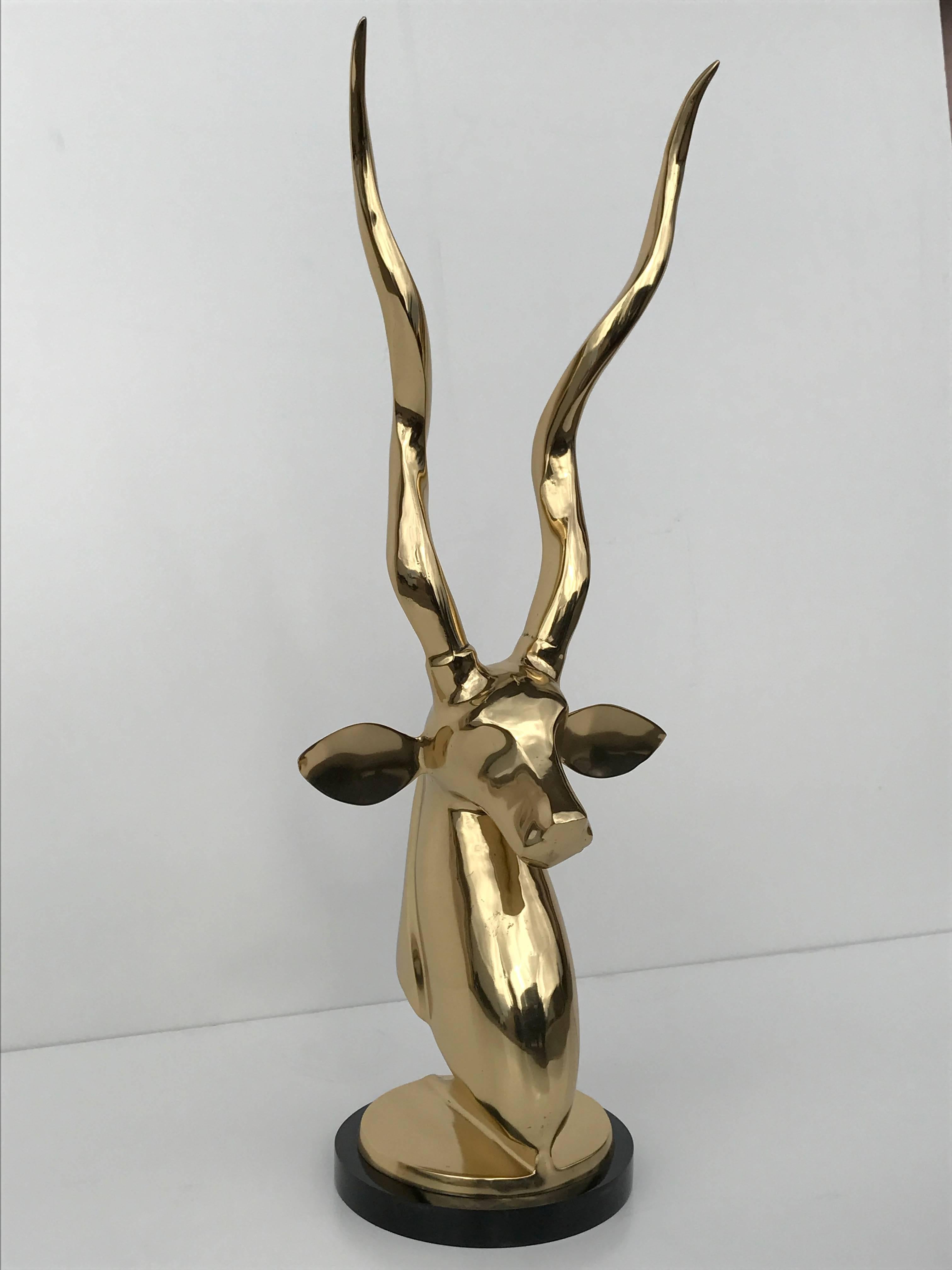Polished brass kudu or impala sculpture bust on black Lucite base.