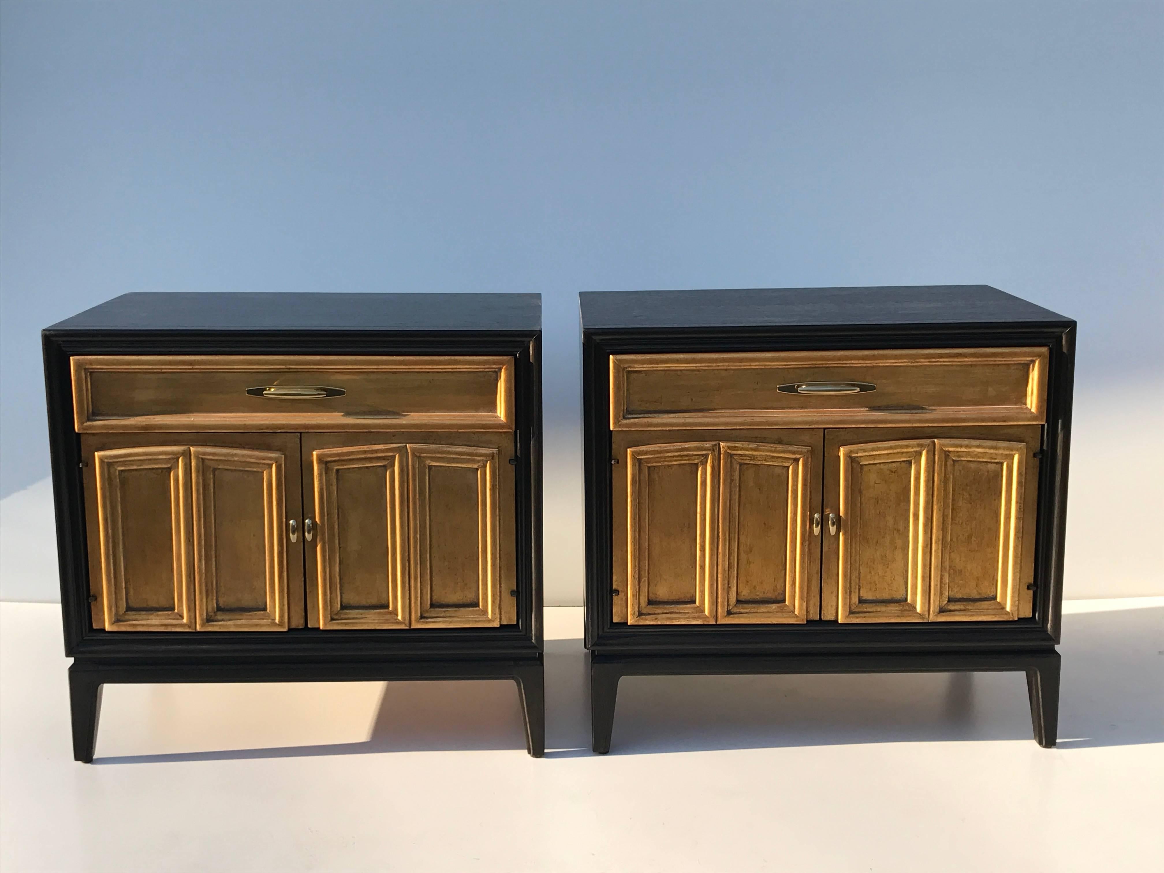Pair of ebonized and gold leafed Hollywood Regency nightstands.