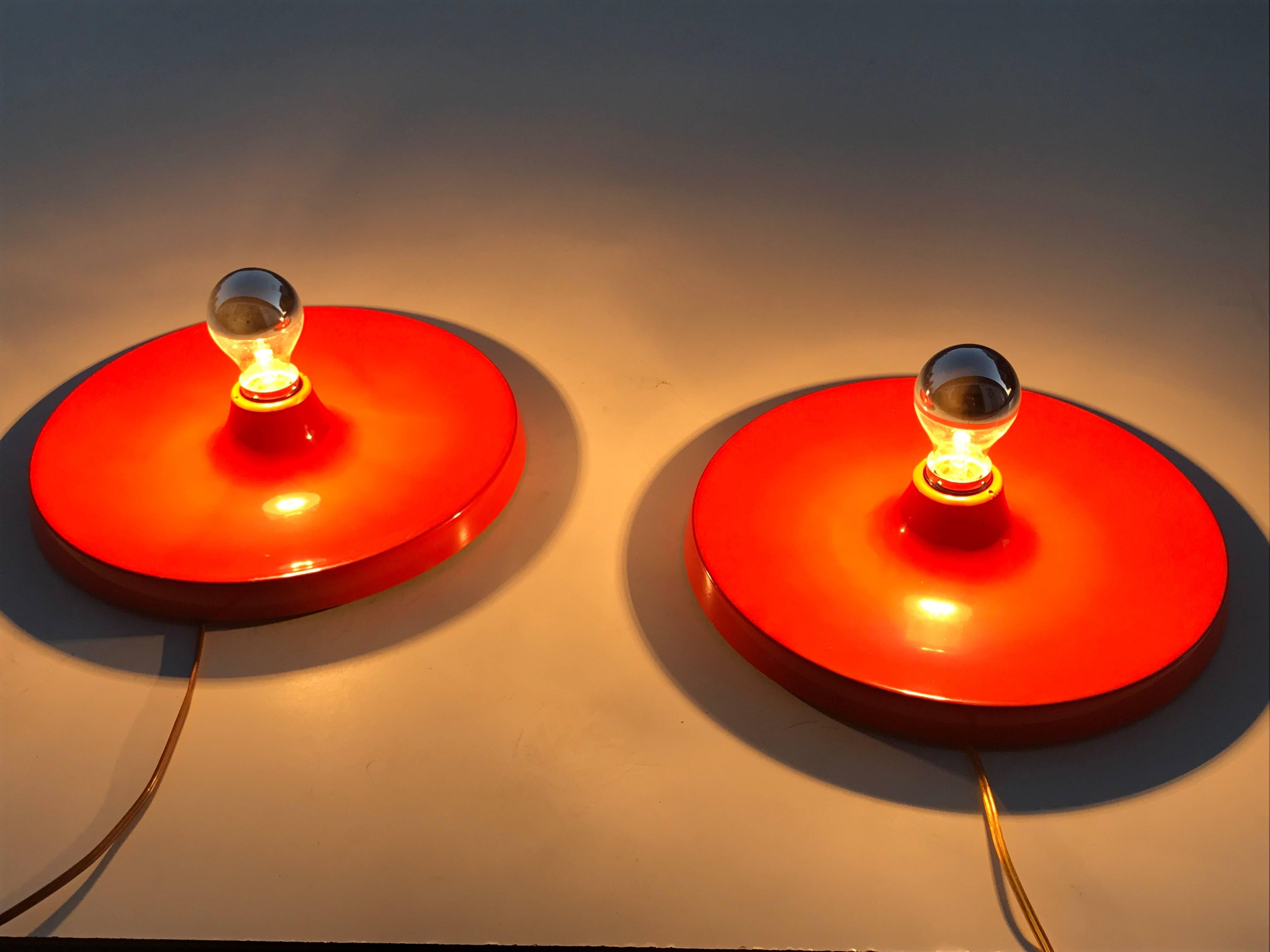 Pair of fire red disk flush mount lights.