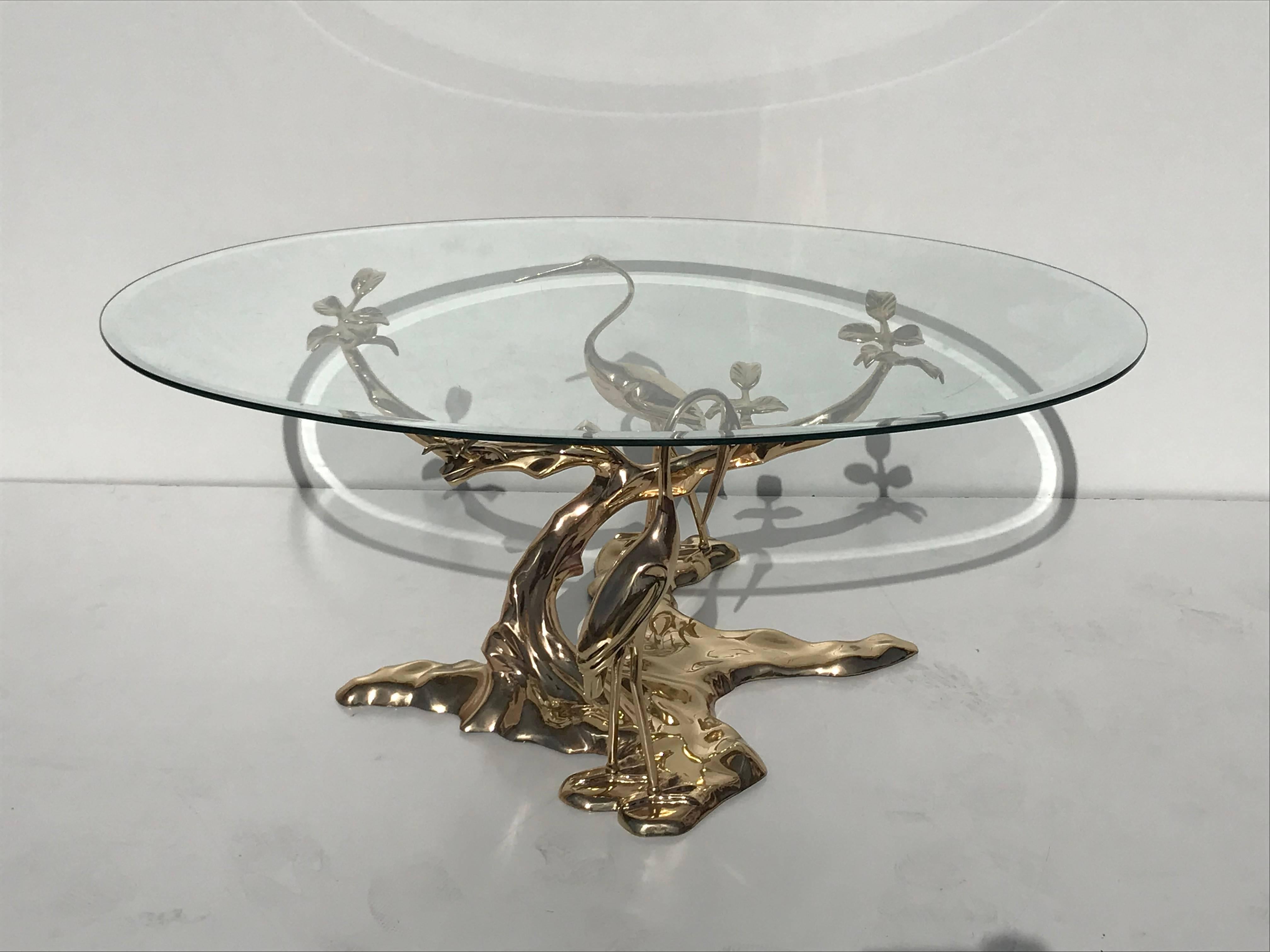 Brass Bonsai tree coffee table with oval glass top. Base measures 27 inches by 27 inches and 16 inches high.