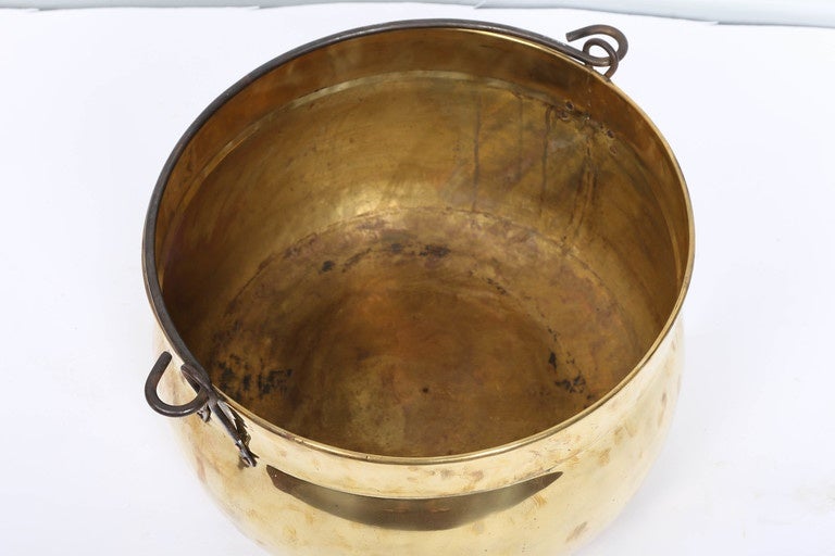 Polished brass kettle with handle.