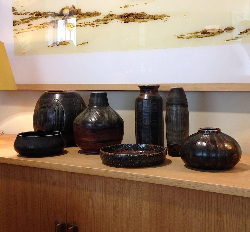 Large group of seven pieces, stoneware glazes in brown, rust and gray, signed R CH Stålhane respective Atelier CHS, Sweden. Vases height varies from 12.5 to 26 cm, one bowl has a height of 8 cm, diameter 19, the 2nd bowl diameter of 23 cm.