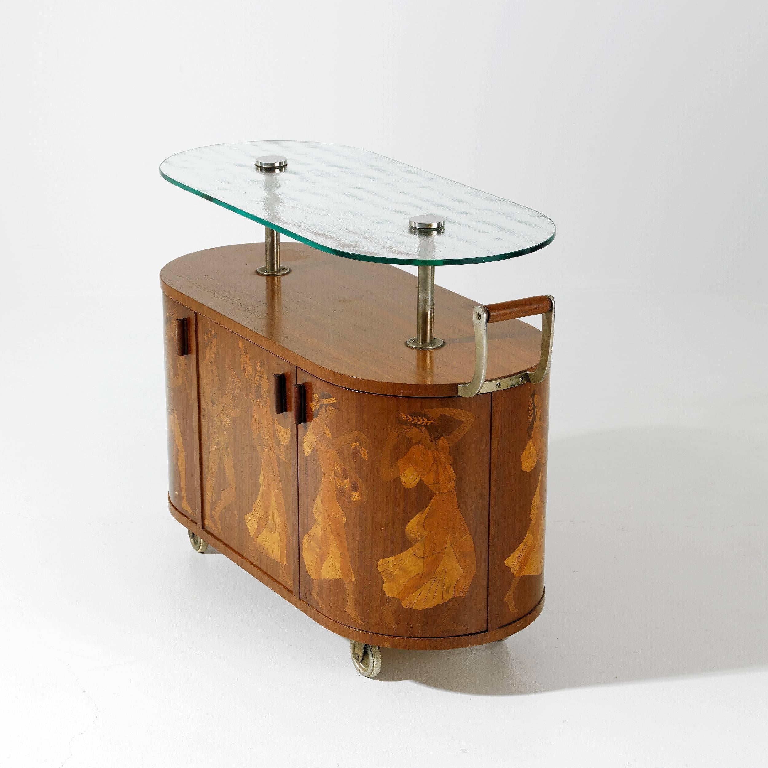 This rare mahogany bar on four wheels with intarsia in different woods depicts the "Bacchusparade". It opens on both front and back with a small drawer on one side in the center. Glass top with chrome fixtures, handle of mahogany and