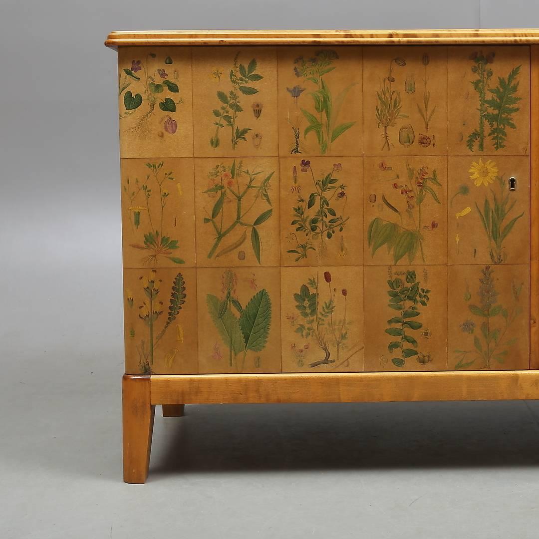 Sideboard stamped SMI, Swedish Mobler Industry, papered with bookpages of Nordens Flora by Lindmann, year 1922. One drawer and two shelves. Key available. Measures: Width 144.5 cm, height 76.5 cm, depth 50 cm.
