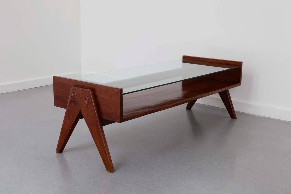 Pierre Jeanneret (1896–1967).

Coffee table,
circa 1955.

Rectangular varnished teak table with two superimposed plates. Opened compartment with an upper glass plate. Side compass-shaped legs. 

Provenance: Special order for the city of