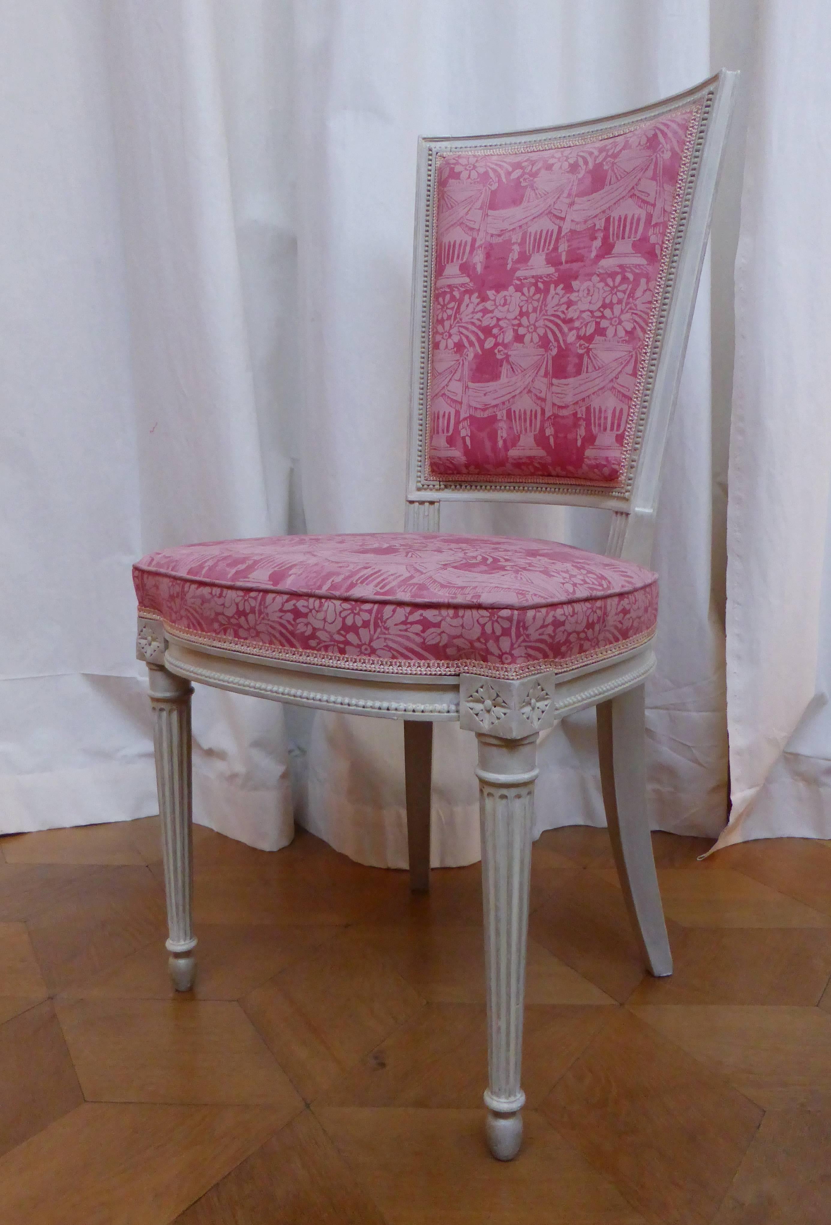 Comprising: a settee, two bergères, two armchairs and two chairs.
Light grey patinated wood, upholstered with a pink fabric with a decoration of urns with flowers and swags. 
dimensions:
settee: h. 95 x w. 132 x d. 60 cm, seat height: 50