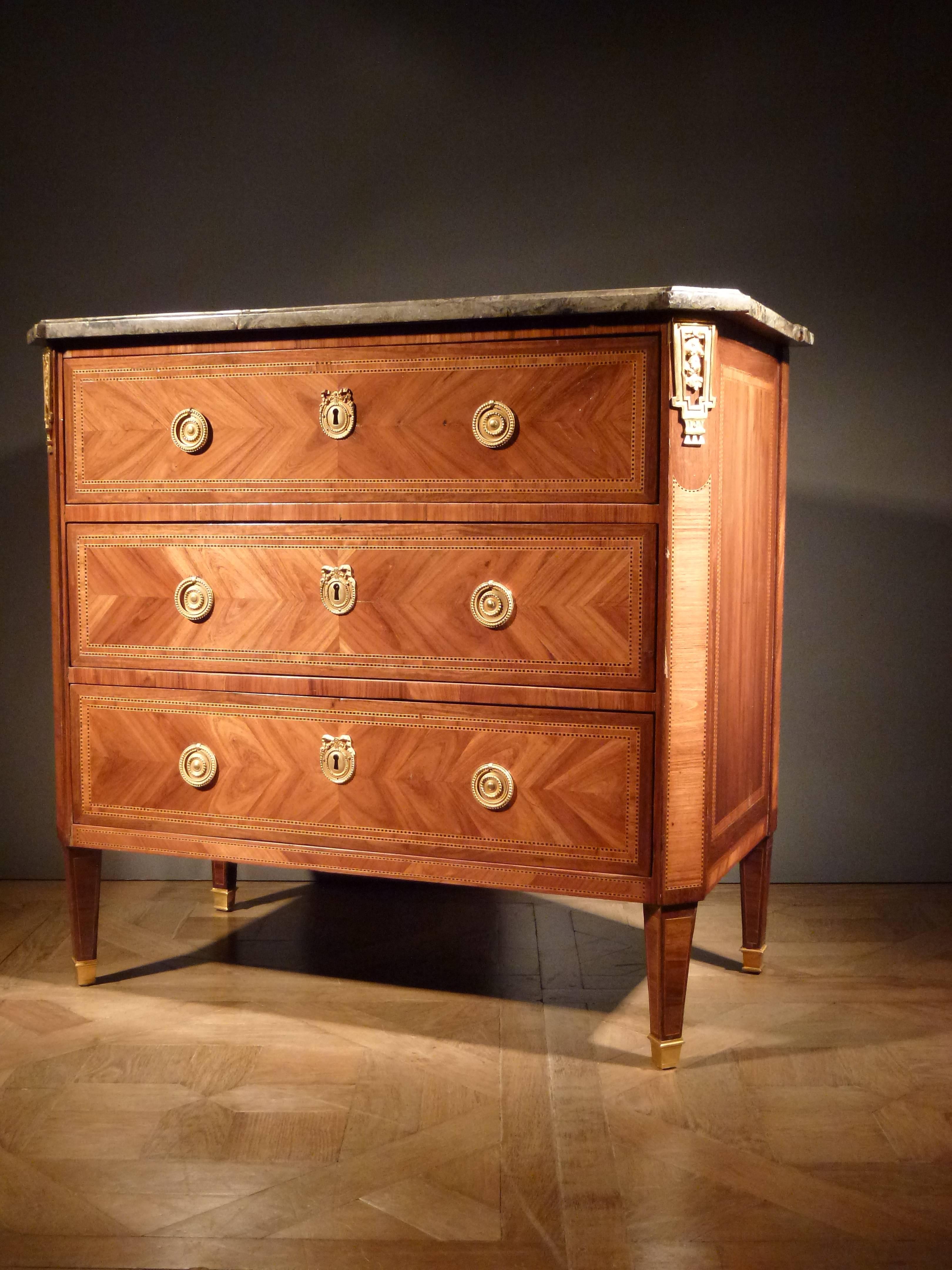 Veneered with tulipwood and mahogany.
The grey marble top above three quarter veneered drawers, canted corners with ormolu mounts on tapered legs with ormolu shoes.
Stamped N.PETIT and JME.

Nicolas Petit was appointed Master on the 21st of