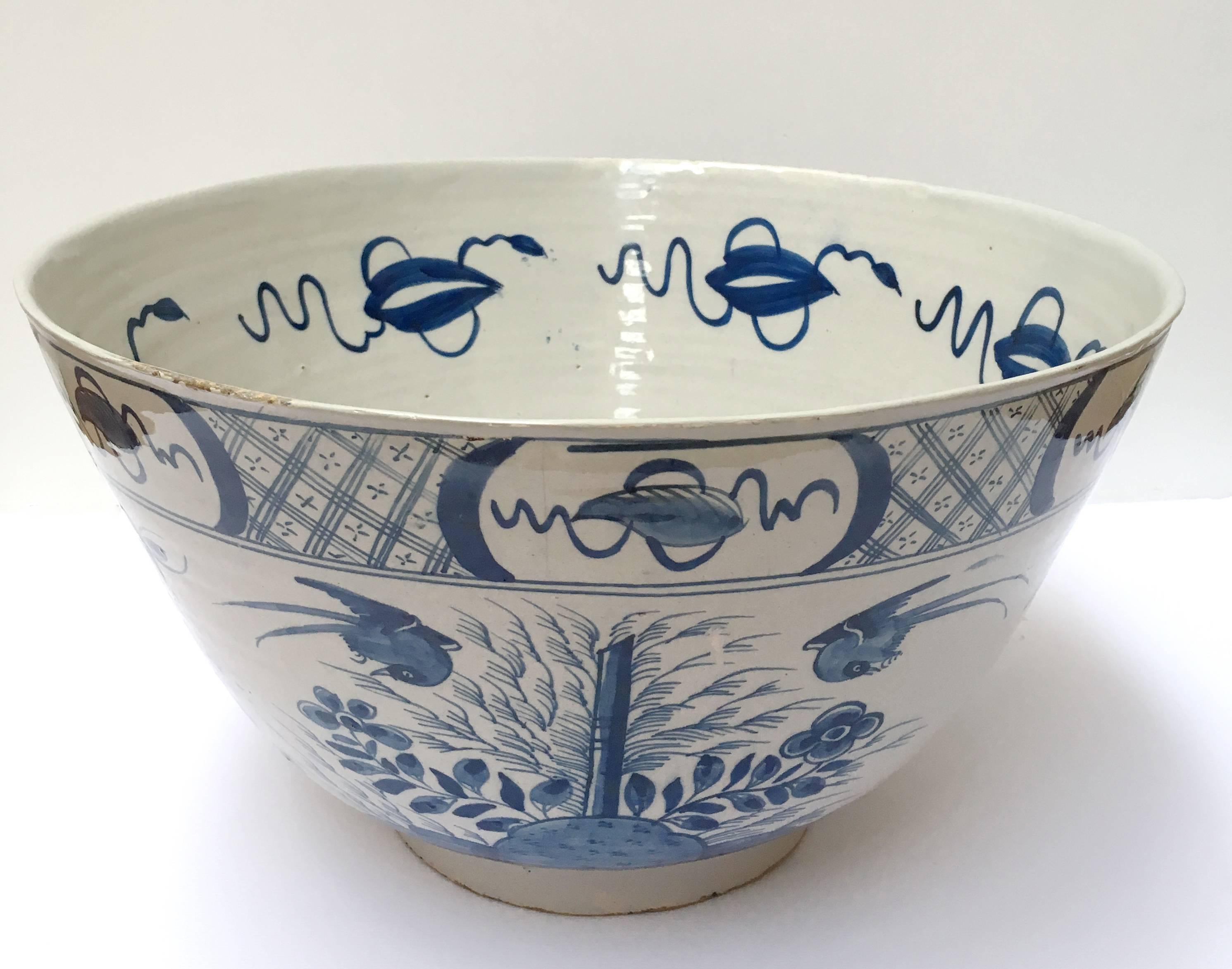 Decorated in blue and white with flowers, birds and blossoming trees, the upper rim with a geometrical pattern and repeating motifs. The interior with a large central flower decoration and repeating motifs to the inner border. 

In the 18th