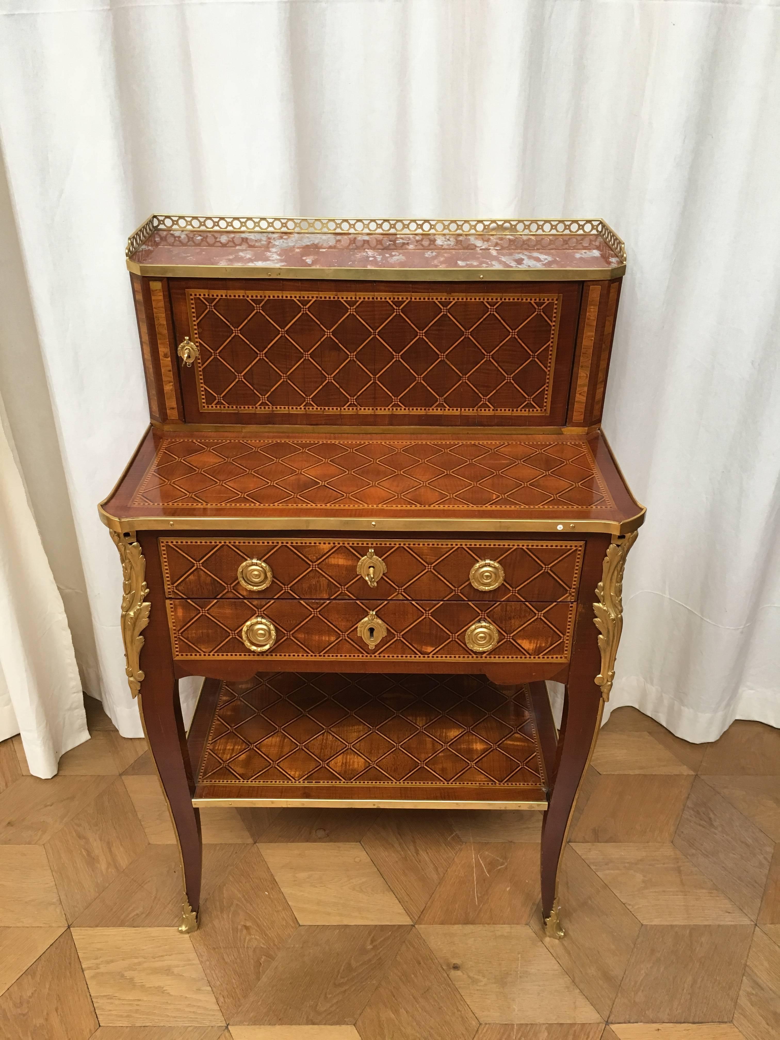 Inlaid overall with a trellis pattern in ebony and boxwood, the raised superstructure with later three-quater galleried red marble top above a tambour shutter enclosing a plain interior, the base with a secretaire drawer with hinged flap above a