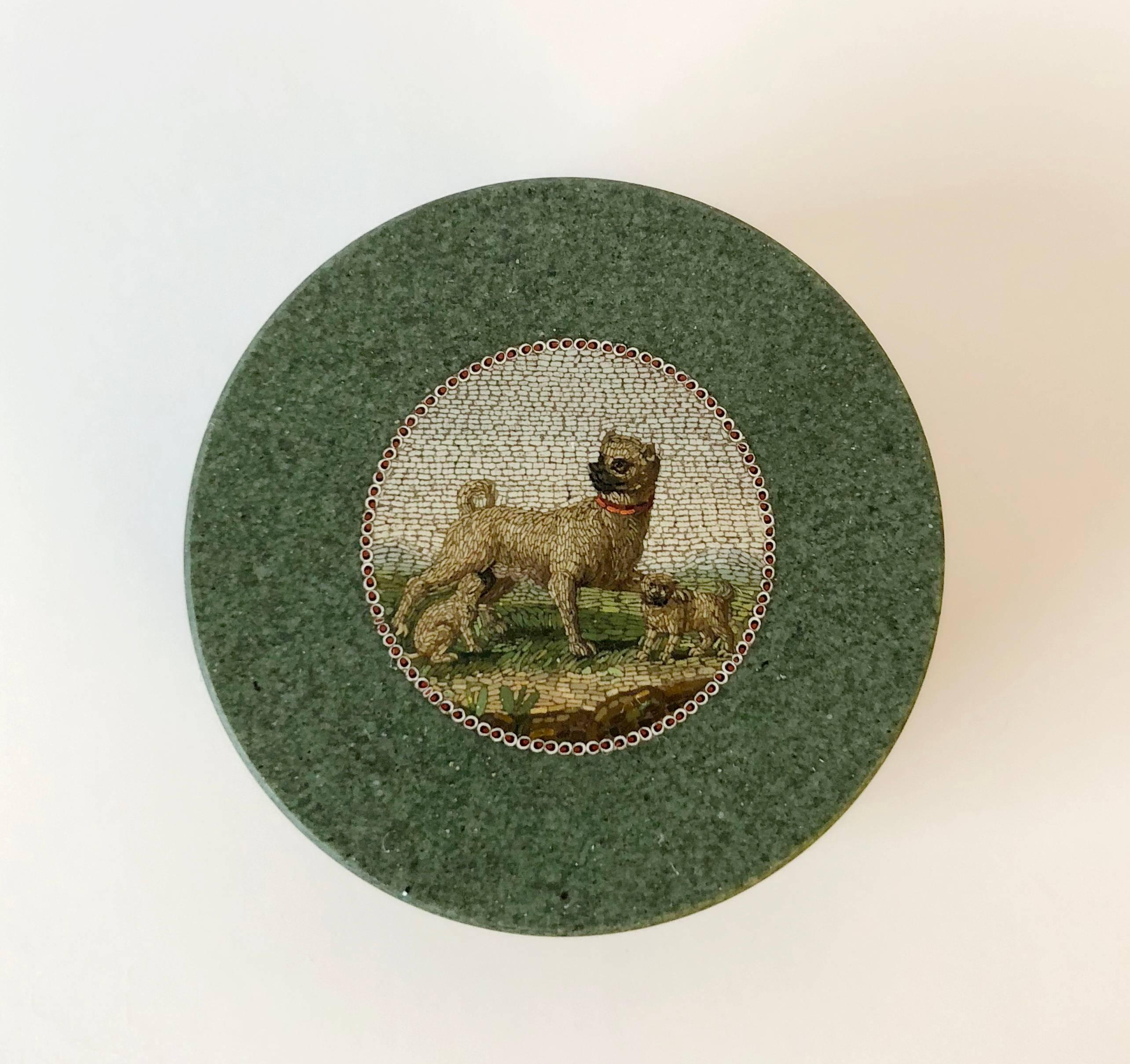 A green hardstone circular box with detachable cover set with a micromosaic depicting a mother dog nursing a puppy and protecting another puppy with her paw. 

Silver marked for Rome and with maker's mark GS 8 in lozenge. 

The micromosaic was