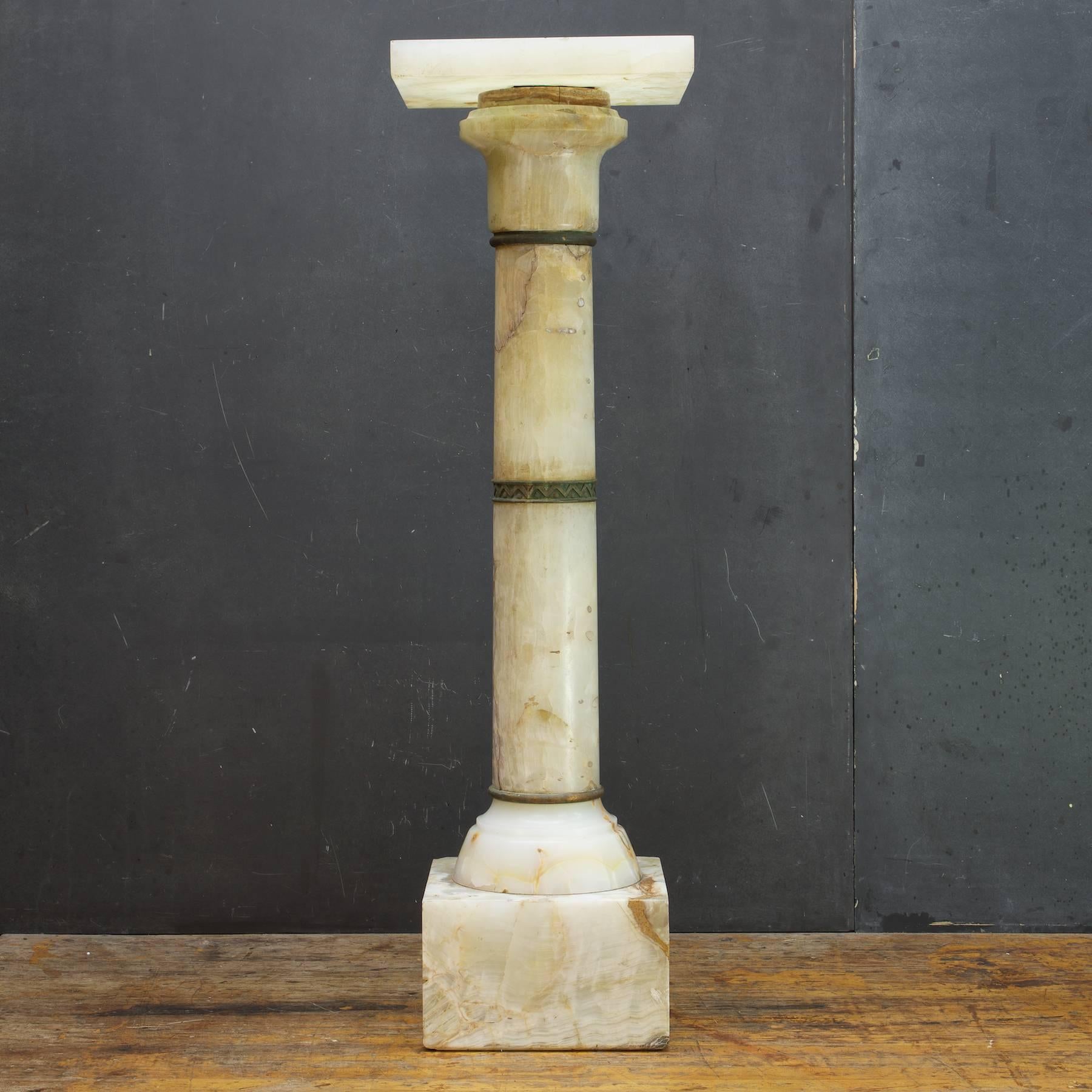 Hollywood Mansion Sculpture Bust Stand, the marble column design is slightly Doric, possibly French. It is ringed with cast bronze metal elements. The top revolves smoothly. 

An antique piece showing its age but very presentable, beautiful and