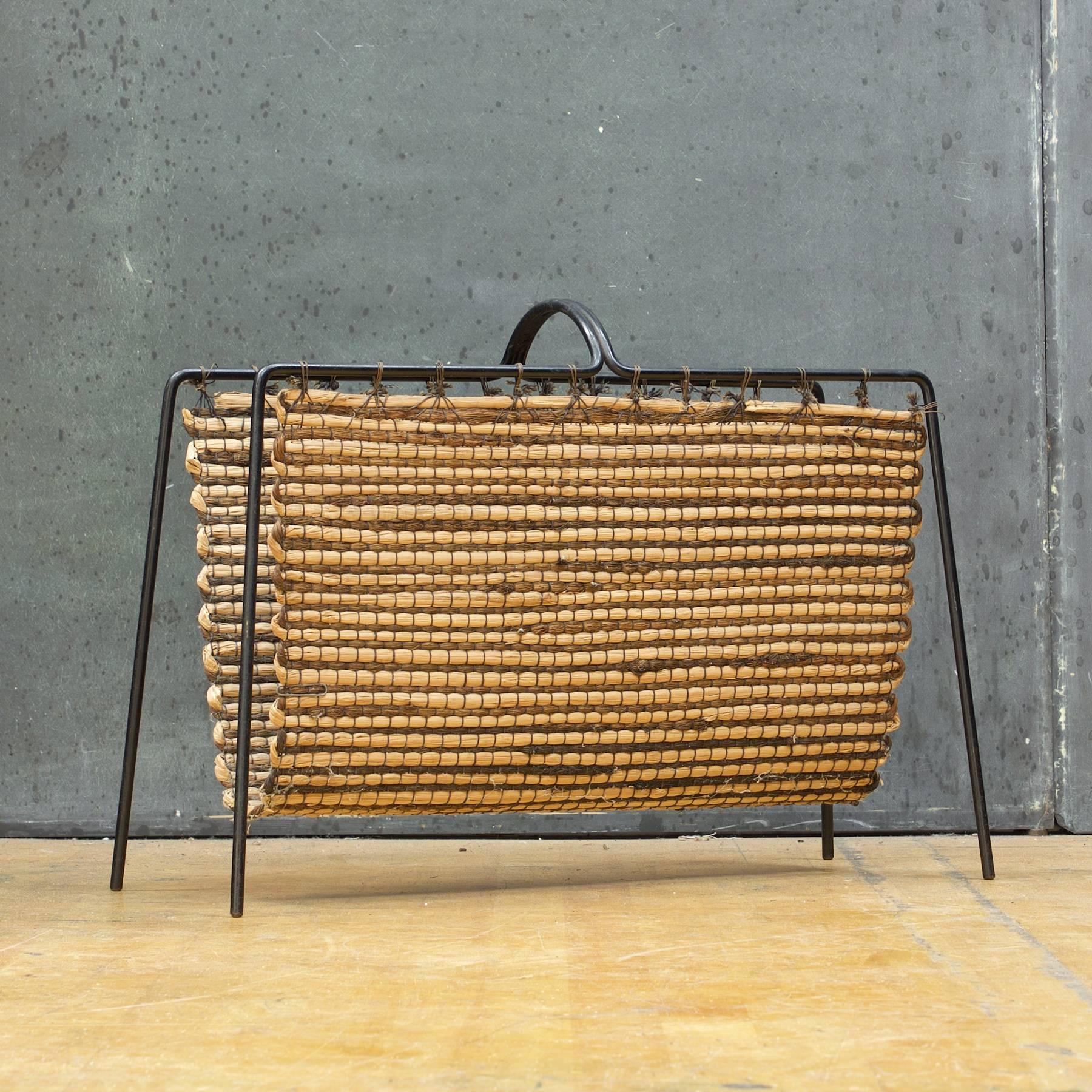 Museum quality Laverne originals magazine rack with original handwoven fiber sling design/made by Geraldine Funk. 

Same leg design applied here as the dowel framed bench, but with the two end loops of the bench swiveled 180 degrees and welded