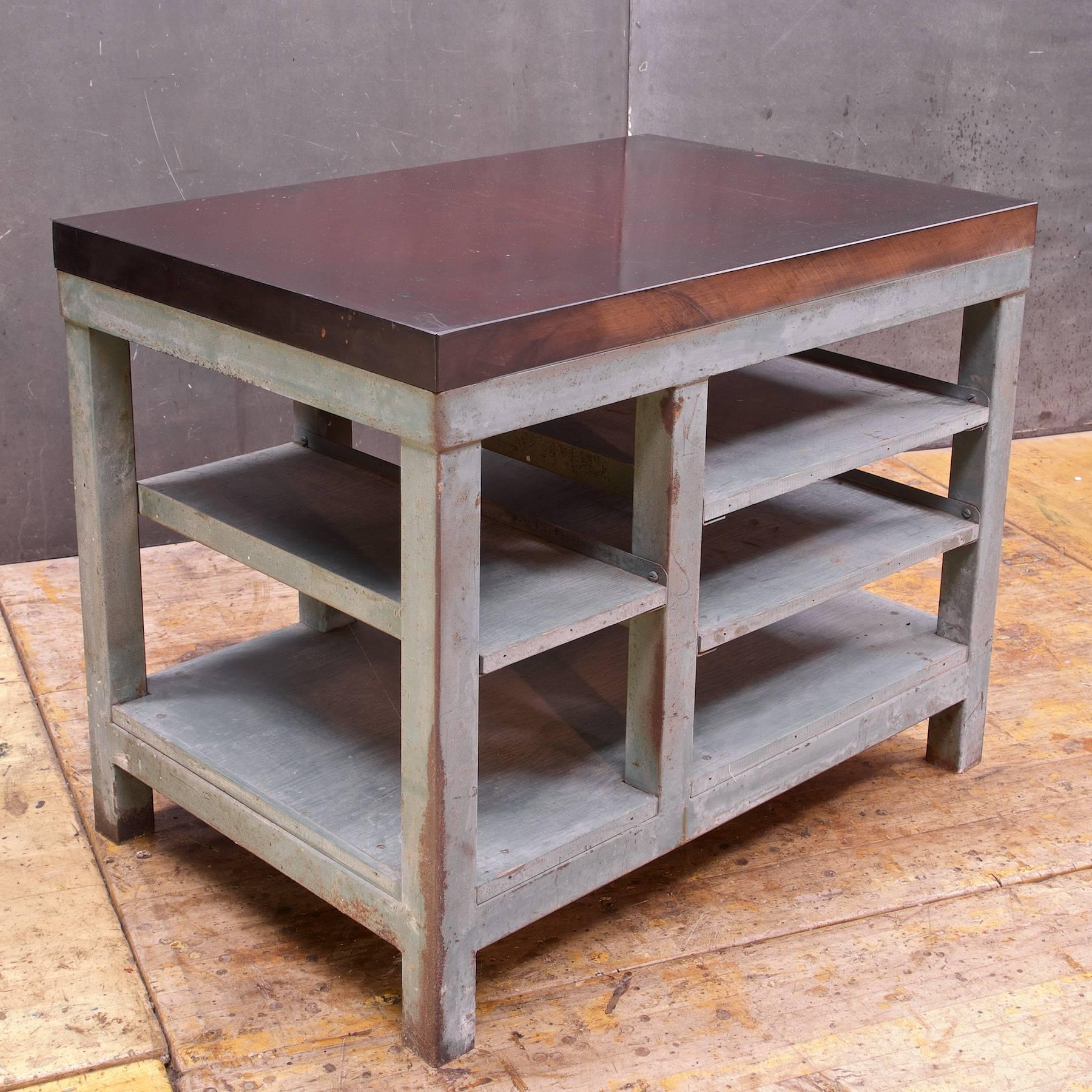 Vintage industrial printmakers stock and set table, USA, circa 1940s. Resin composite flat top, scratched. Edged shelving. Heavier than it looks, around 200lbs. Measures: Shelves L shelf H: 7, 16 in. R shelf H: 7, 13, 19 in.