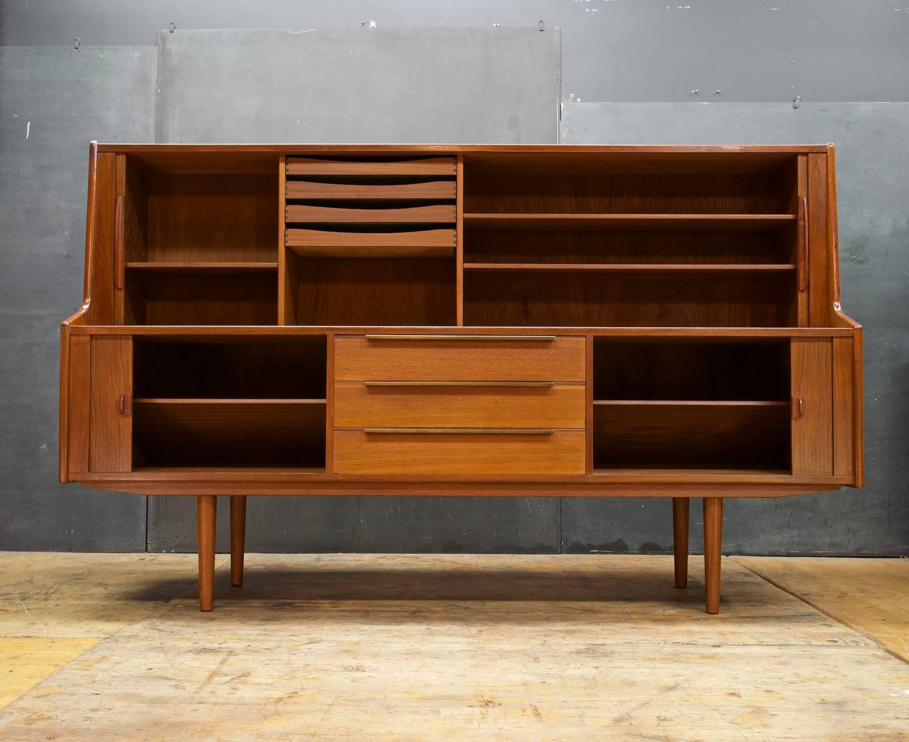 Very large sideboard or cabinet, four fully functioning tambour sliding doors, four flatware drawers, five adjustable shelves. Overall good vintage condition, with some uneven finish on two top surfaces.

Denmark Control Mark inside drawer.