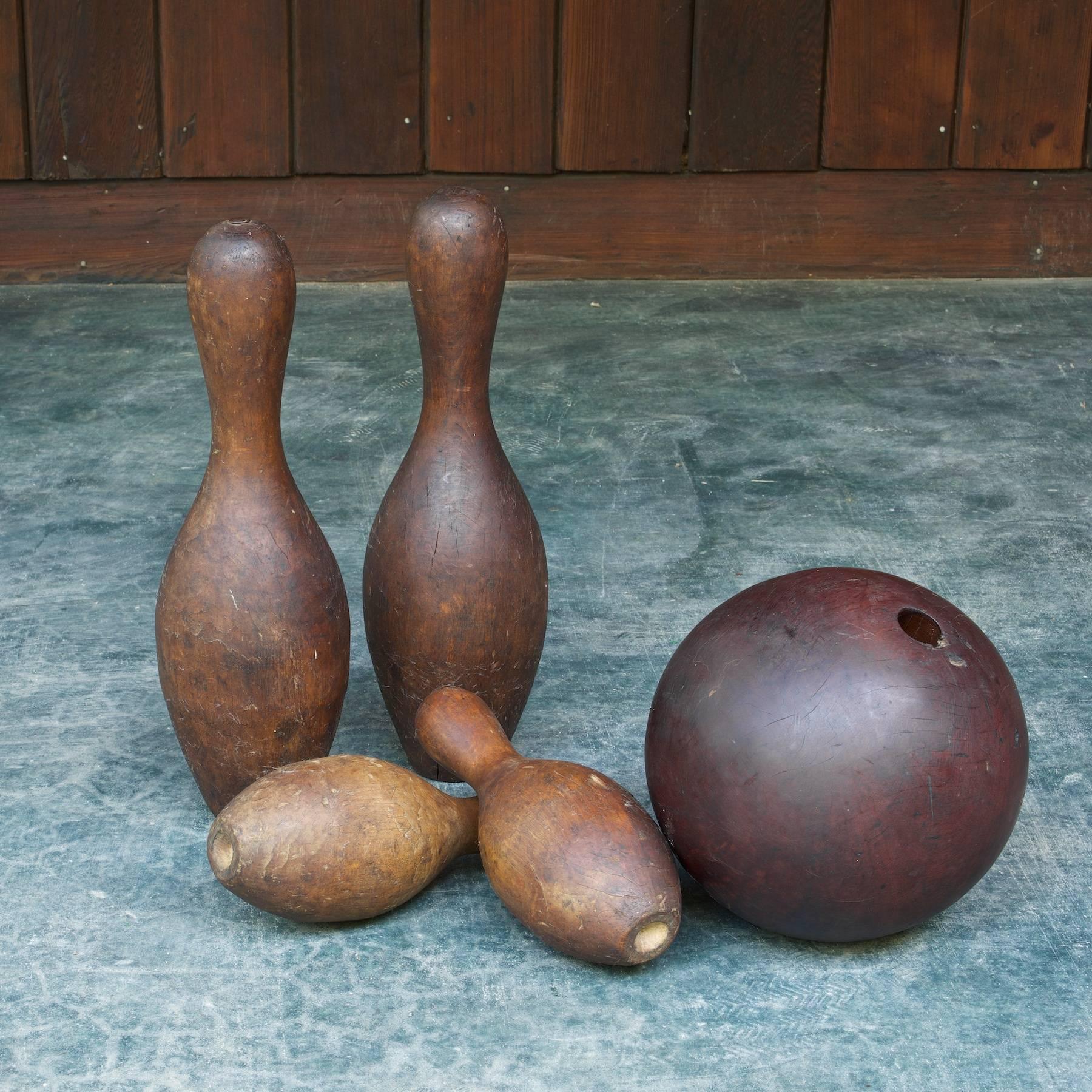 Antique lignum vitae lathe turned bowling ball with four pins. 

Measures: Ball diameter: 9 in.
Ten pins diameter: 5 x height 15 in.
Duck pins diameter: 4 x height 9.5 in.

 