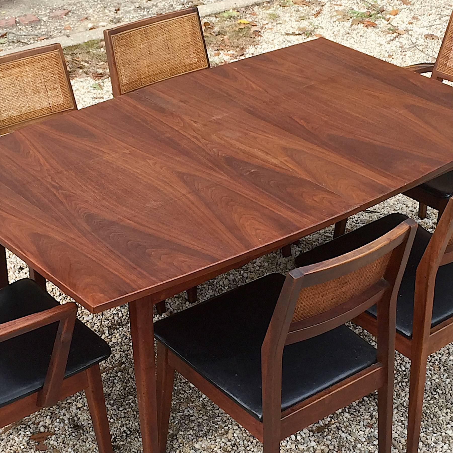 Estate fresh. Six chairs and table. Entire American modern old growth walnut dining set included, no leaves with table but have protective pads. Solid walnut armchairs and side chairs with cane/wicker/rattan backrests.

Good vintage condition,