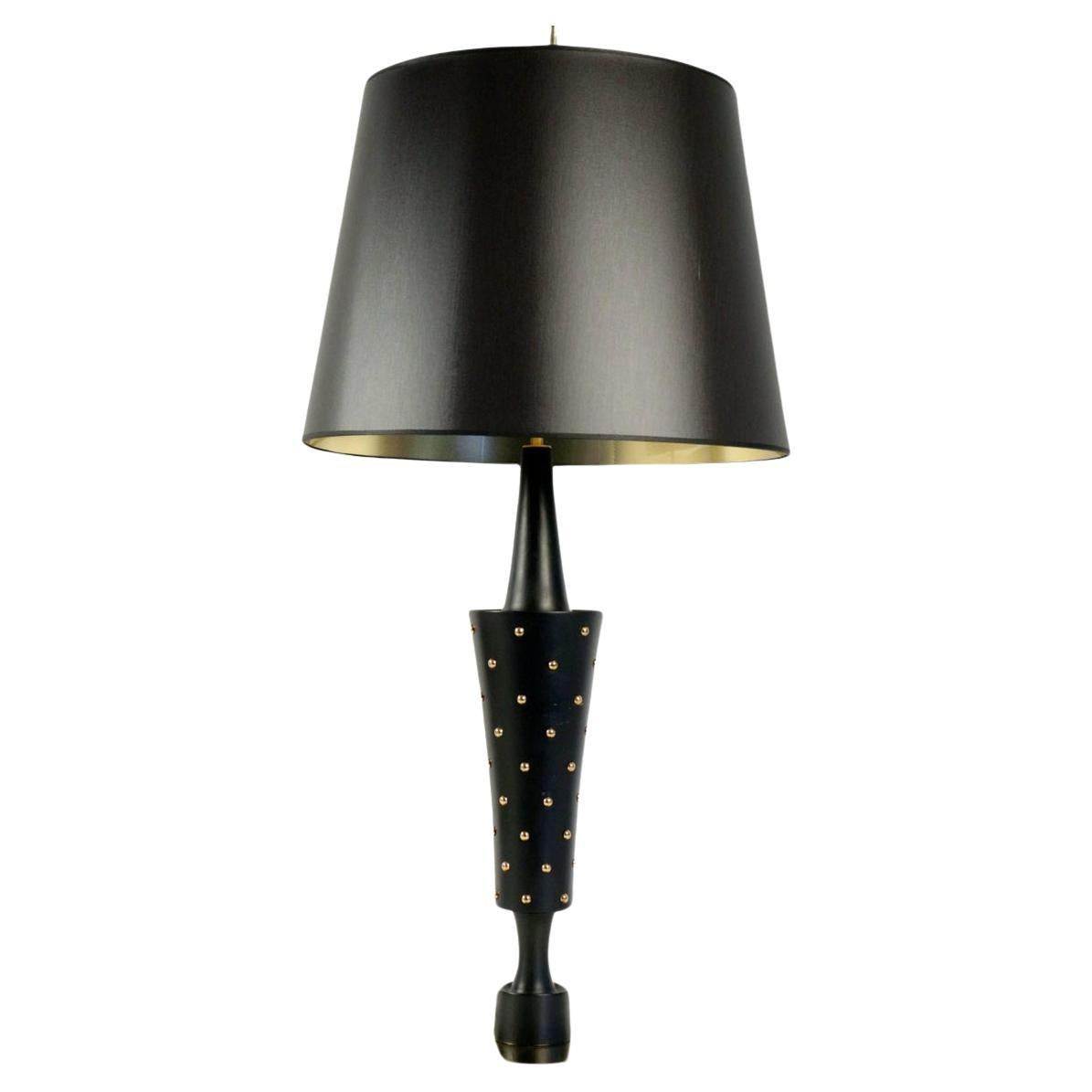 1950s Stilnovo Style large table lamp.

The base is made of a large gilded brass disc. The stem of the lamp in the shape of a vase is made of wood turned in black satin lacquer and entirely dressed with golden brass nails. 
Large lampshade,