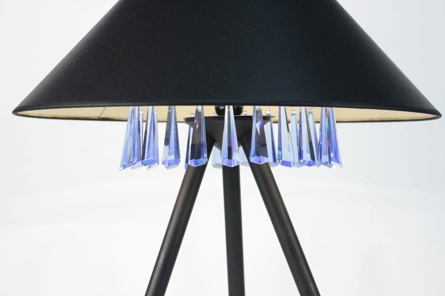 1970s table lamp for Galerie Chrystiane Charles, 1970.
Referenced on the catalog.
Black lacquered metal base with brass ball endings. 
Tripod base. Frieze with a pearl decor holding blue glass daggers.
Gold inside color and black outside